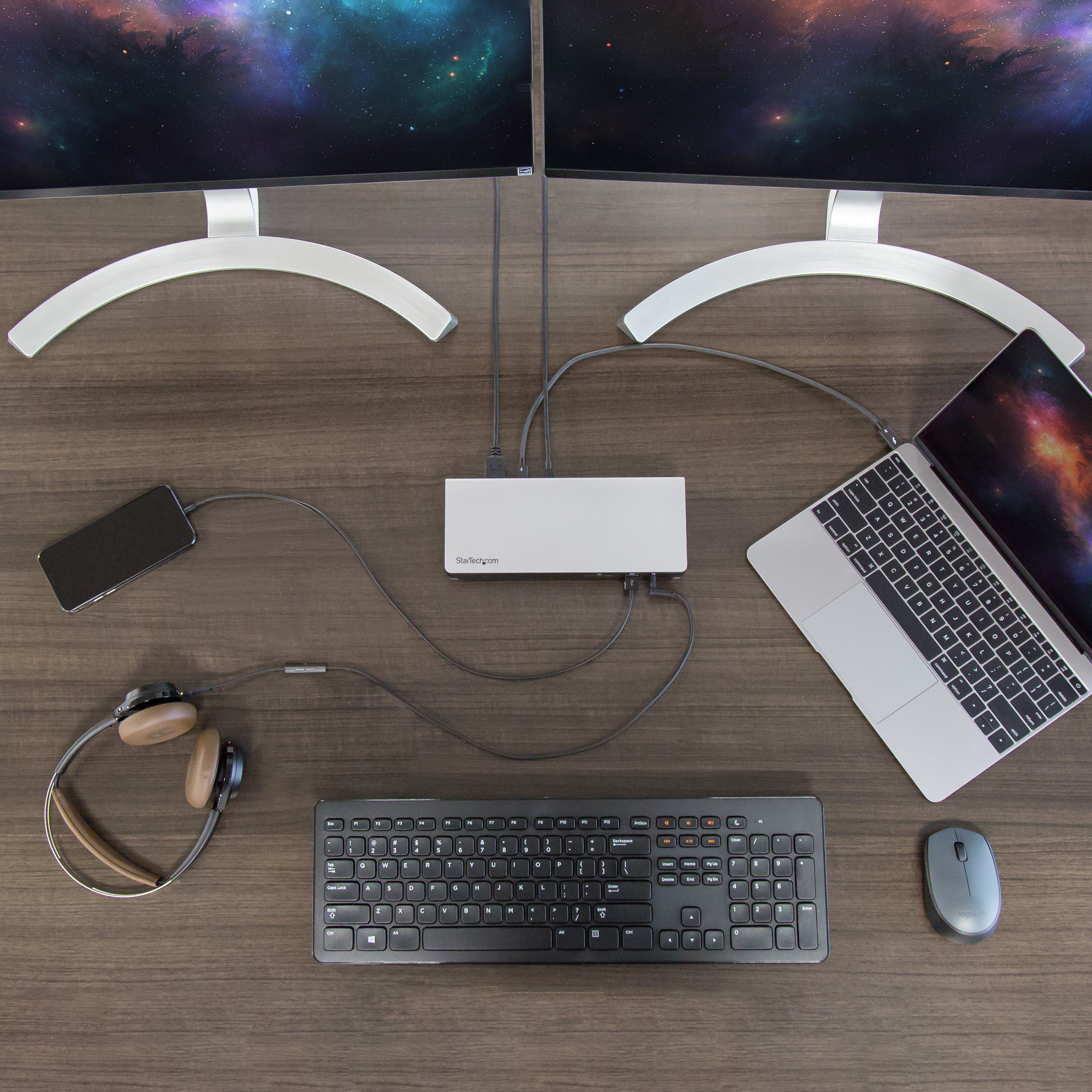 Ein Schreibtisch-Setup mit zwei Monitoren, einem Laptop, Tastatur, Maus, Kopfhörern und einem Hub.