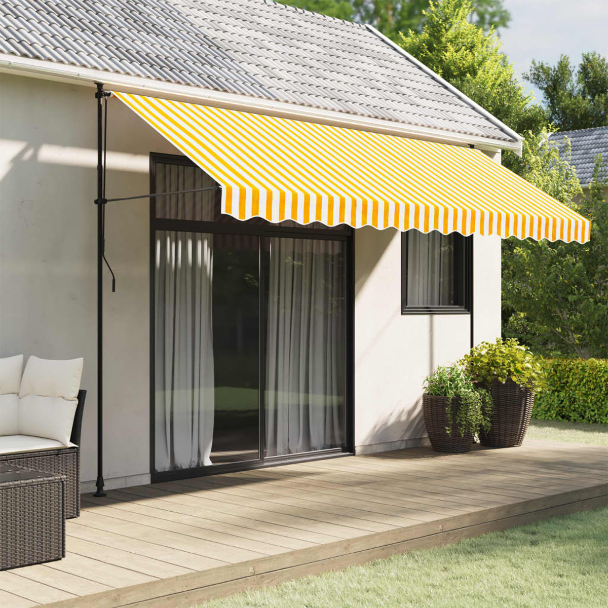Ein Haus mit einer gelb-weiß gestreiften Markise. Es gibt eine Holzterrasse und eine Sitzecke.