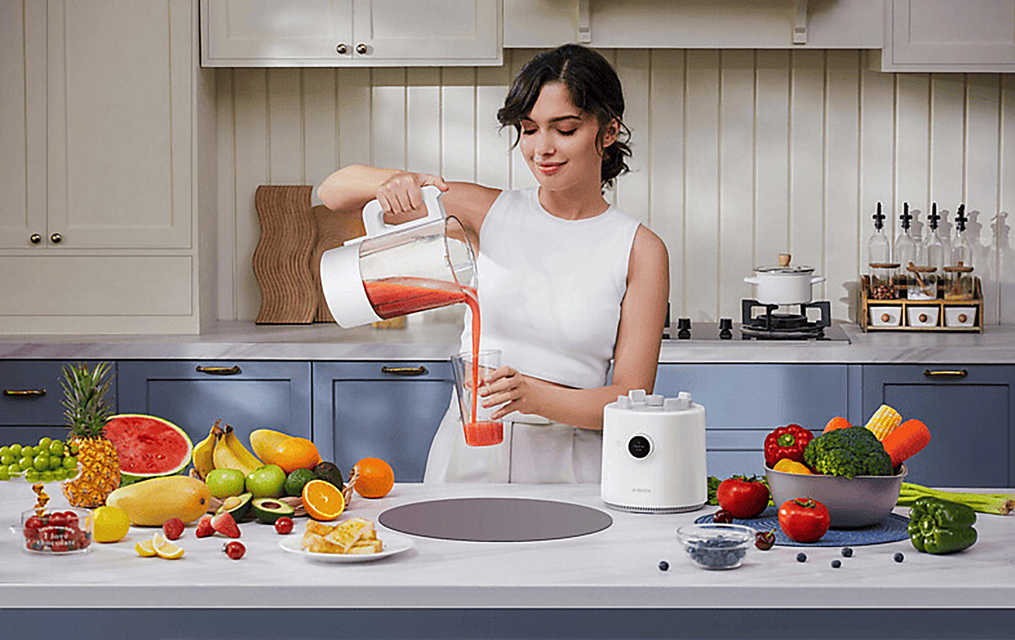 Een vrouw schenkt rood sap in een glas in een keuken met fruit en groenten.