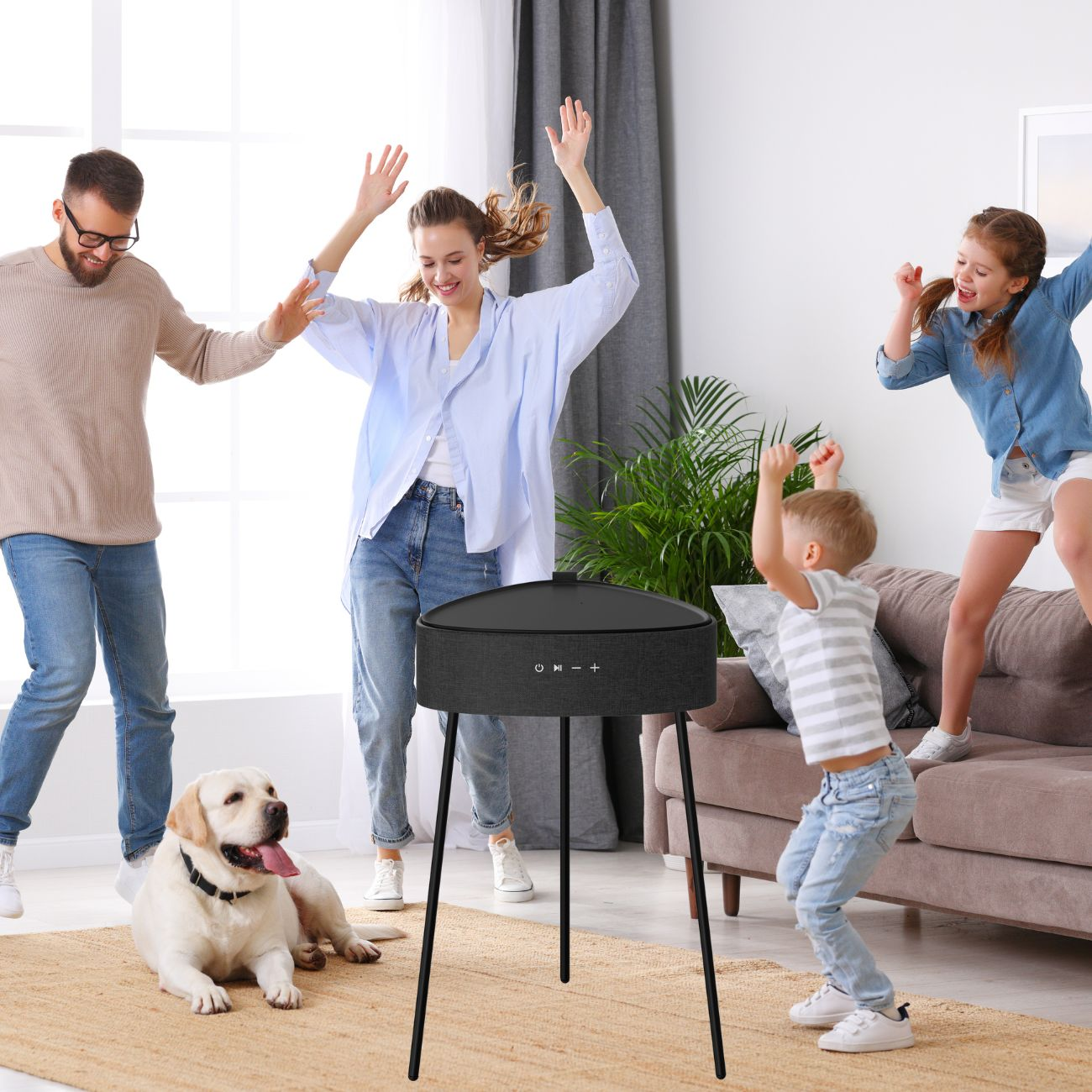 Eine vierköpfige Familie tanzt um einen Lautsprecher, im Vordergrund ein Hund.