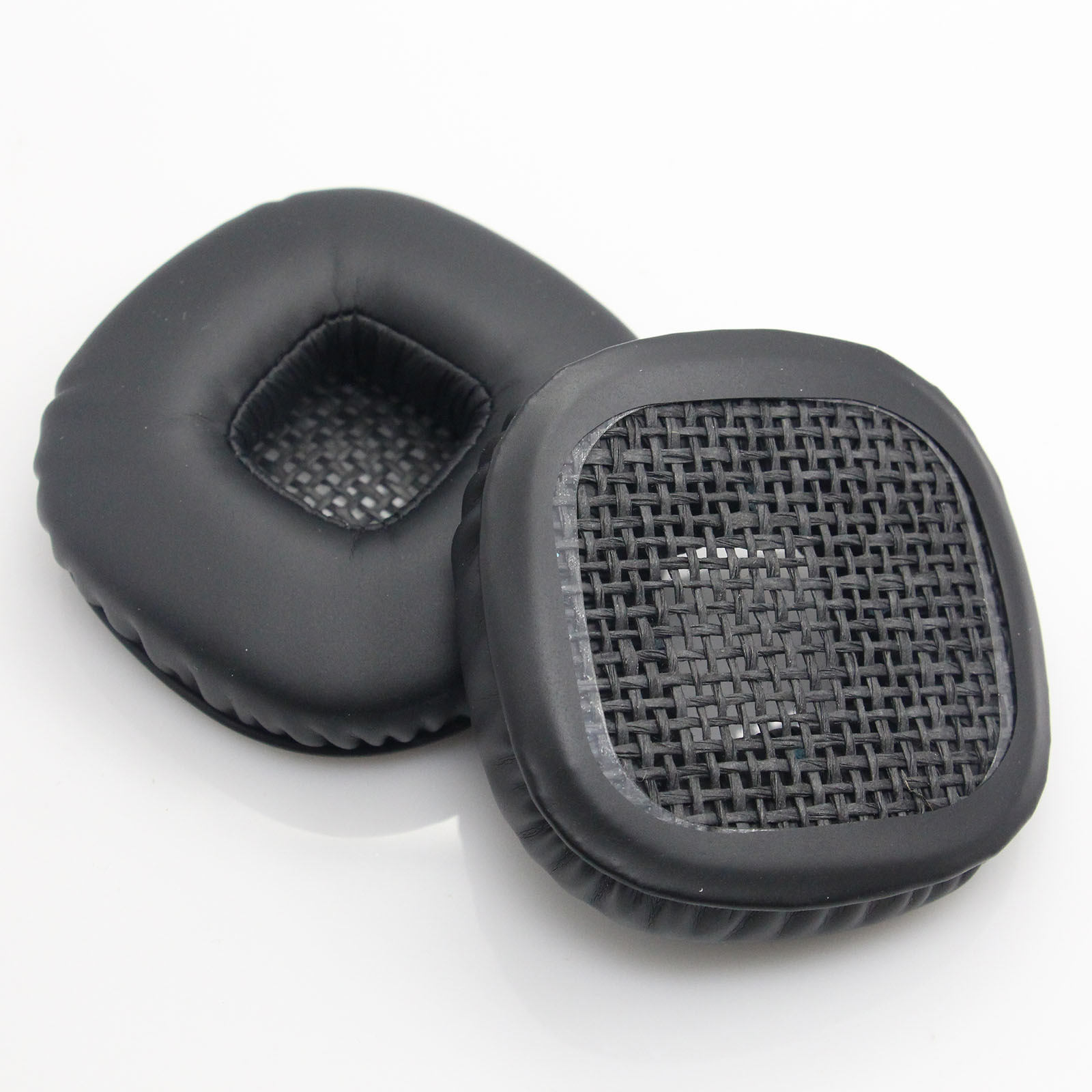 Dwie czarne poduszki na uszy. Jedna jest pełna, druga ma siatkową osłonę. Obie są kwadratowe z zaokrąglonymi rogami.