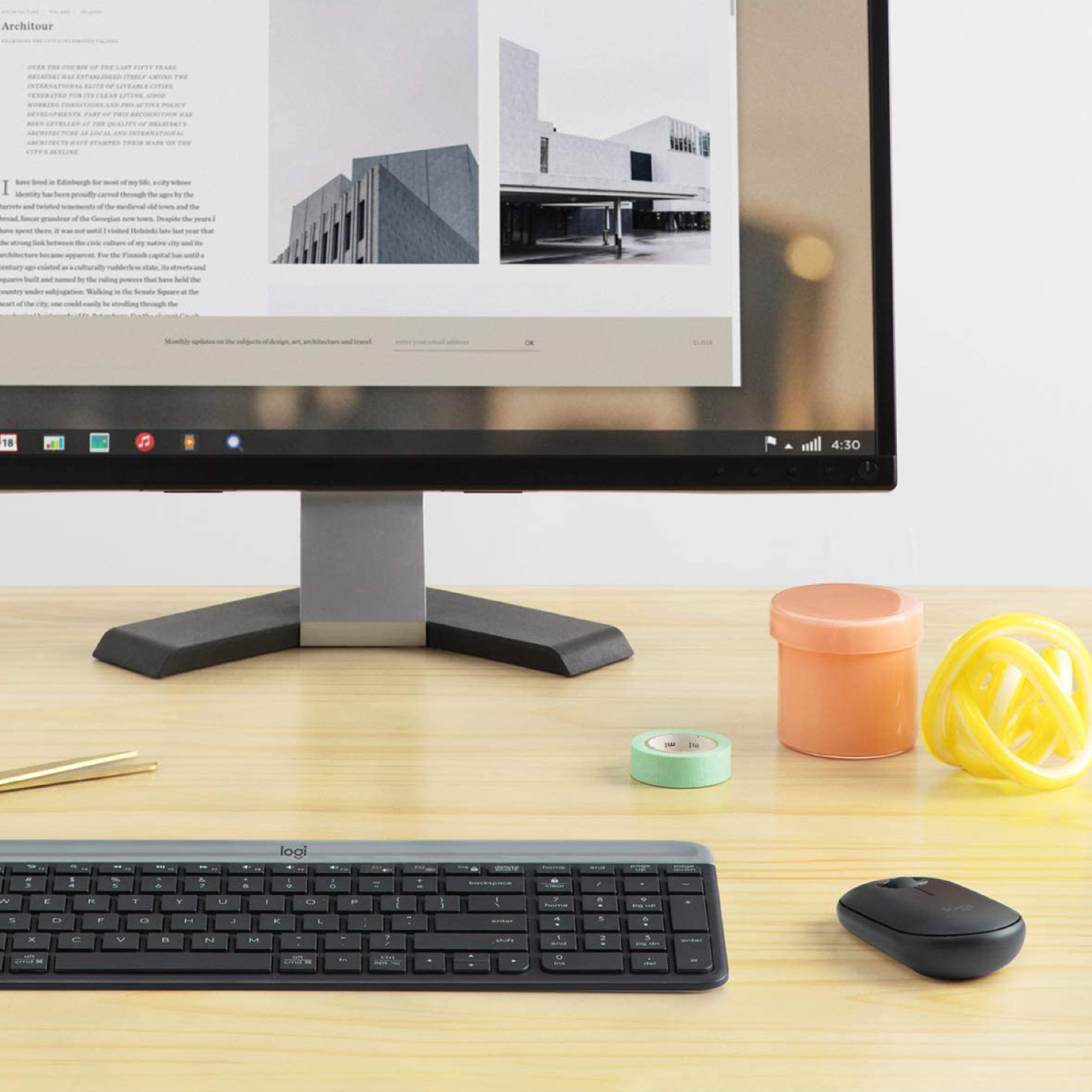 Schreibtisch-Setup mit Monitor, Tastatur, Maus und Dekoration.