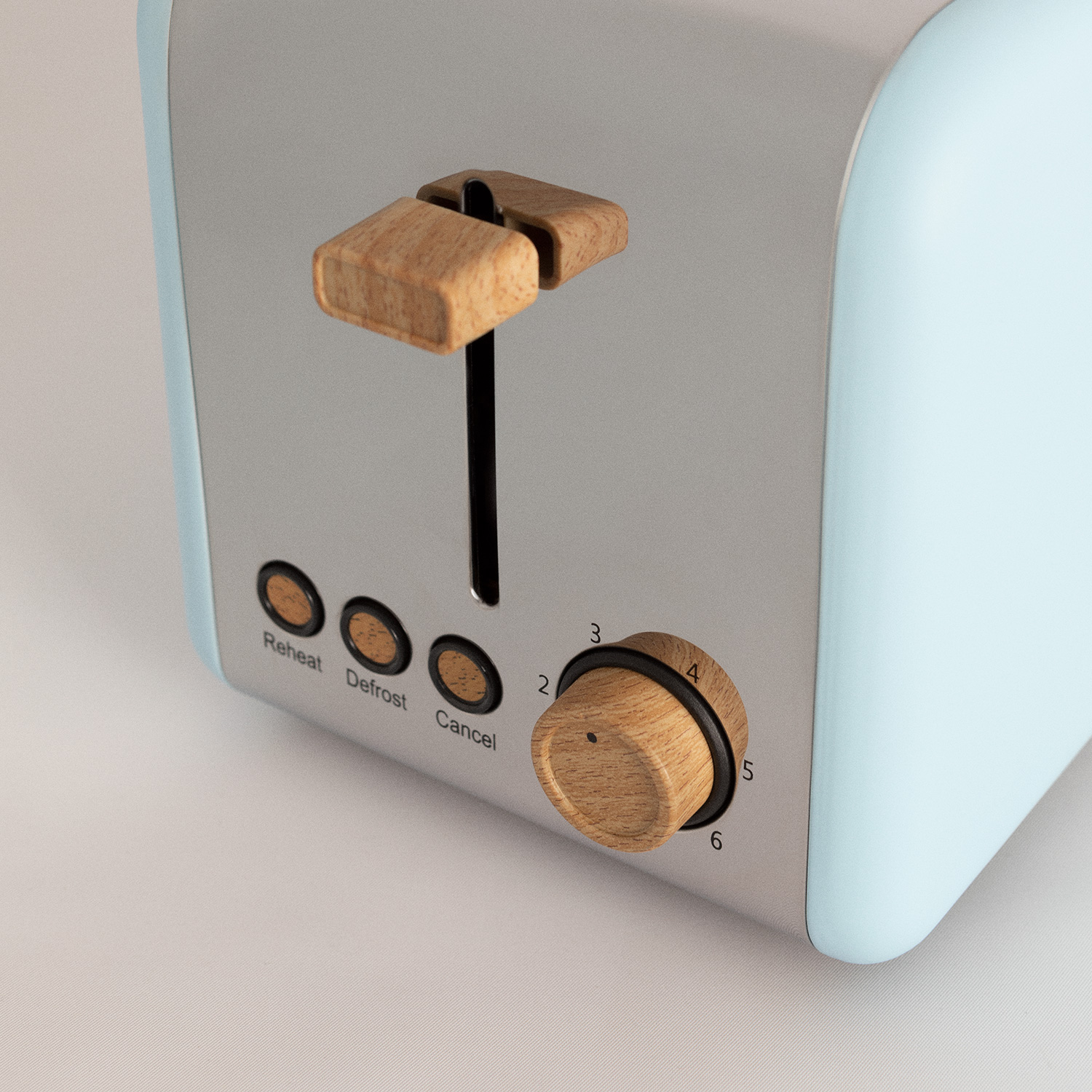 Un primer plano de una tostadora azul y plateada. Tiene controles de madera y un dial.
