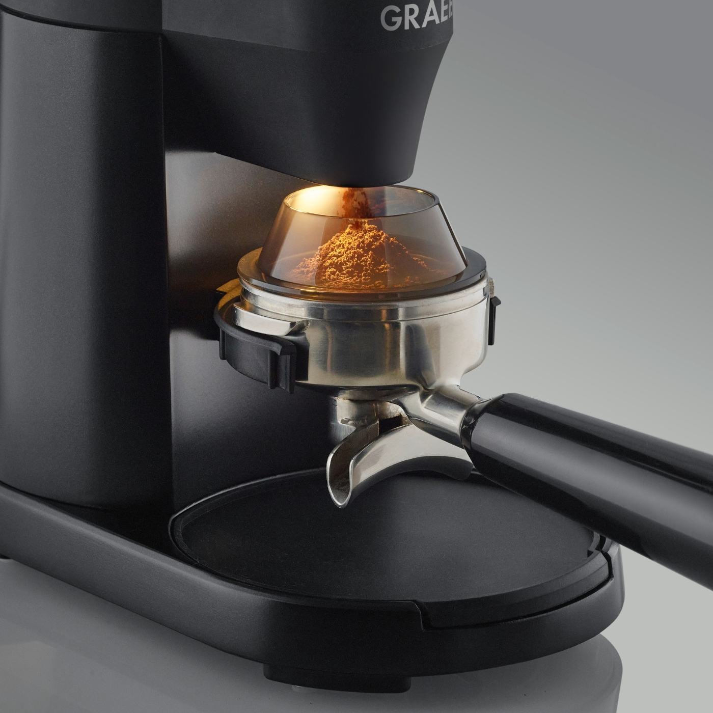 Un macinacaffè nero con caffè macinato nel portafiltro.