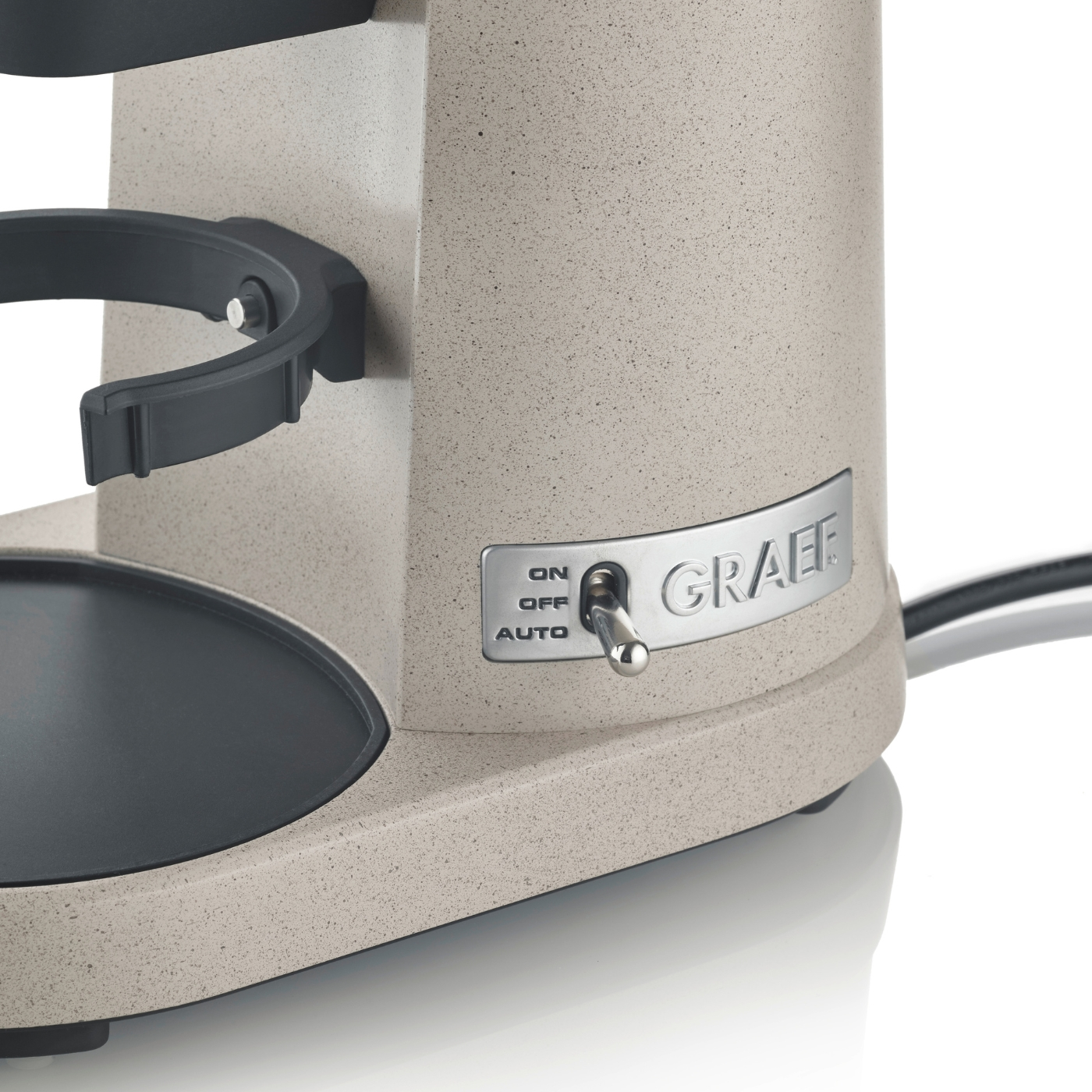 Nahaufnahme einer beigen Kaffeemühle mit 'GRAEF'-Logo und Netzschalter.