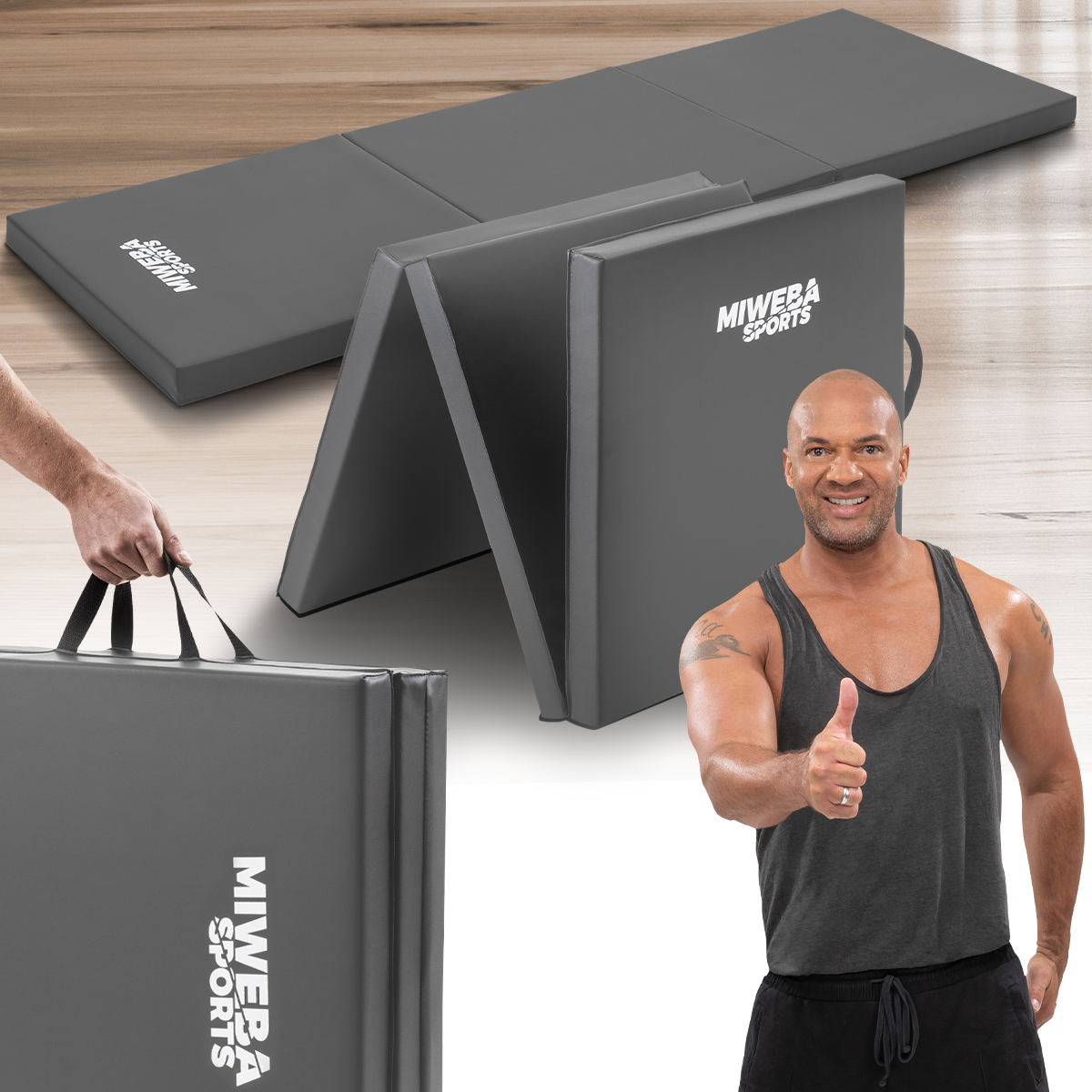 Gefaltete graue Trainingsmatte und Mann mit Daumen hoch. Matte hat Logo.