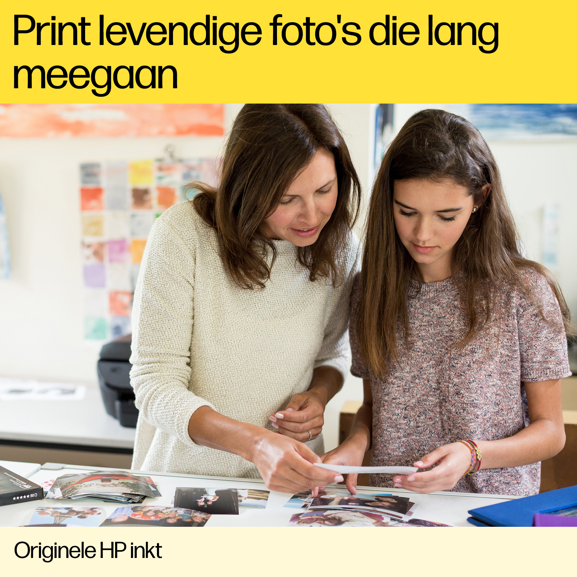 Zwei Frauen betrachten gedruckte Fotos. Text auf Niederländisch oben.