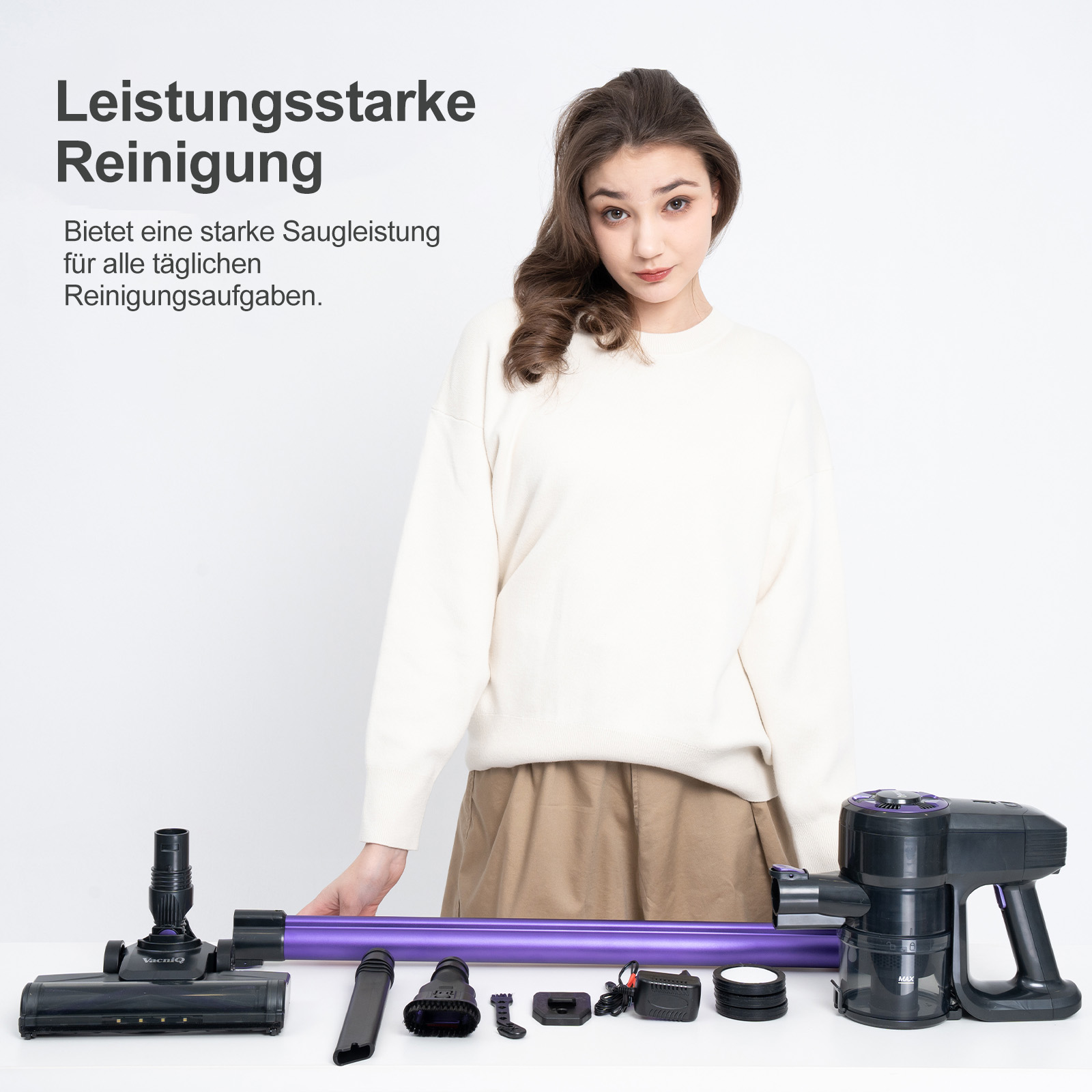 Eine Frau mit Staubsauger und Zubehör auf weißer Oberfläche.