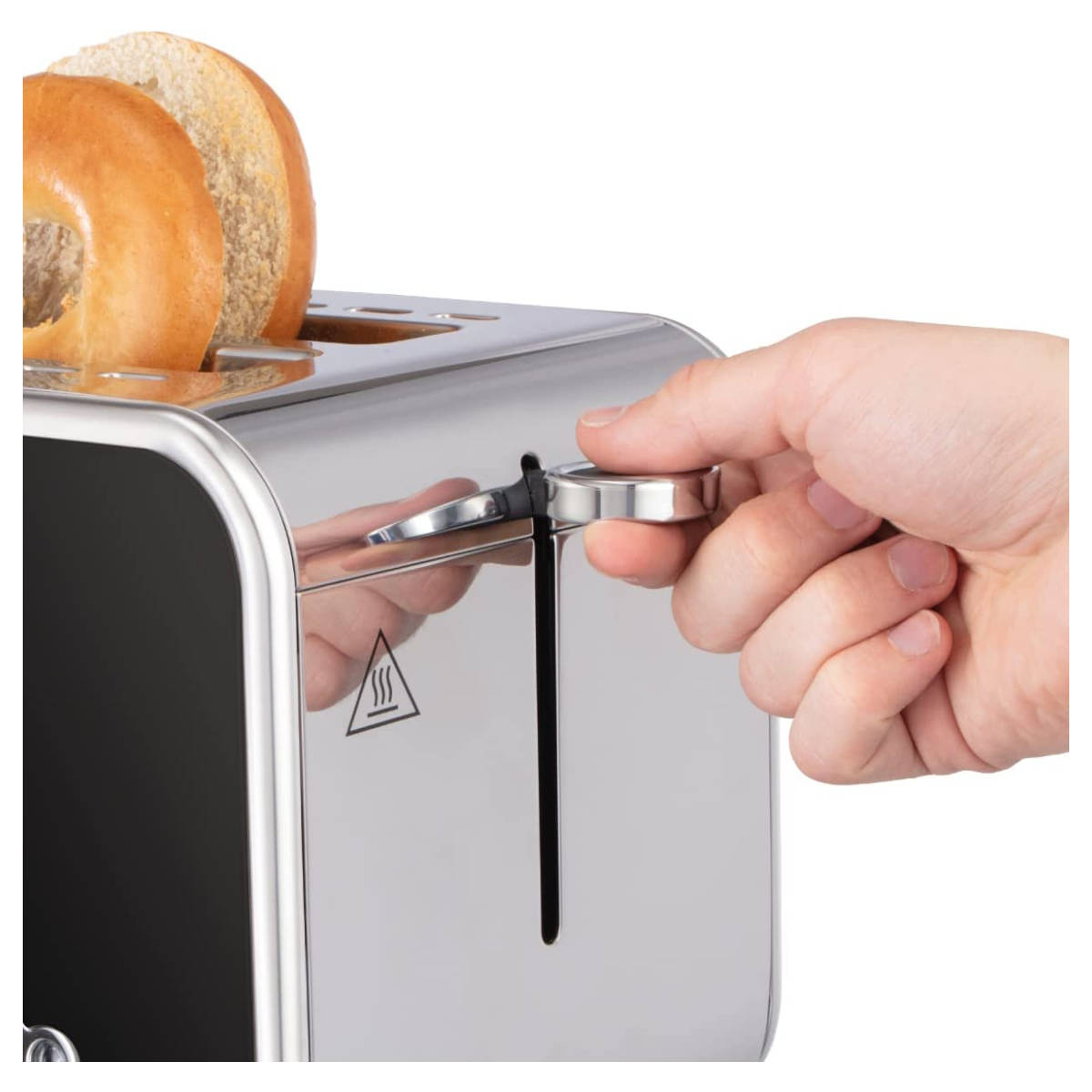 Une main appuyant sur un levier d'un grille-pain argenté avec des tranches de pain à l'intérieur.
