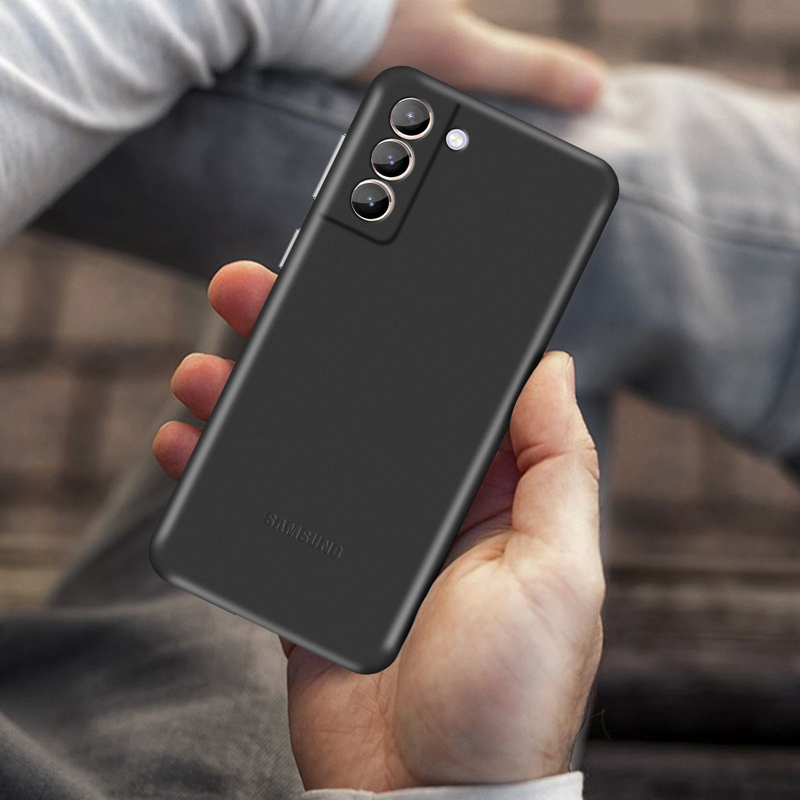 Die Hand einer Person hält ein schwarzes Telefon mit drei Kameras. Das Samsung-Logo ist sichtbar.