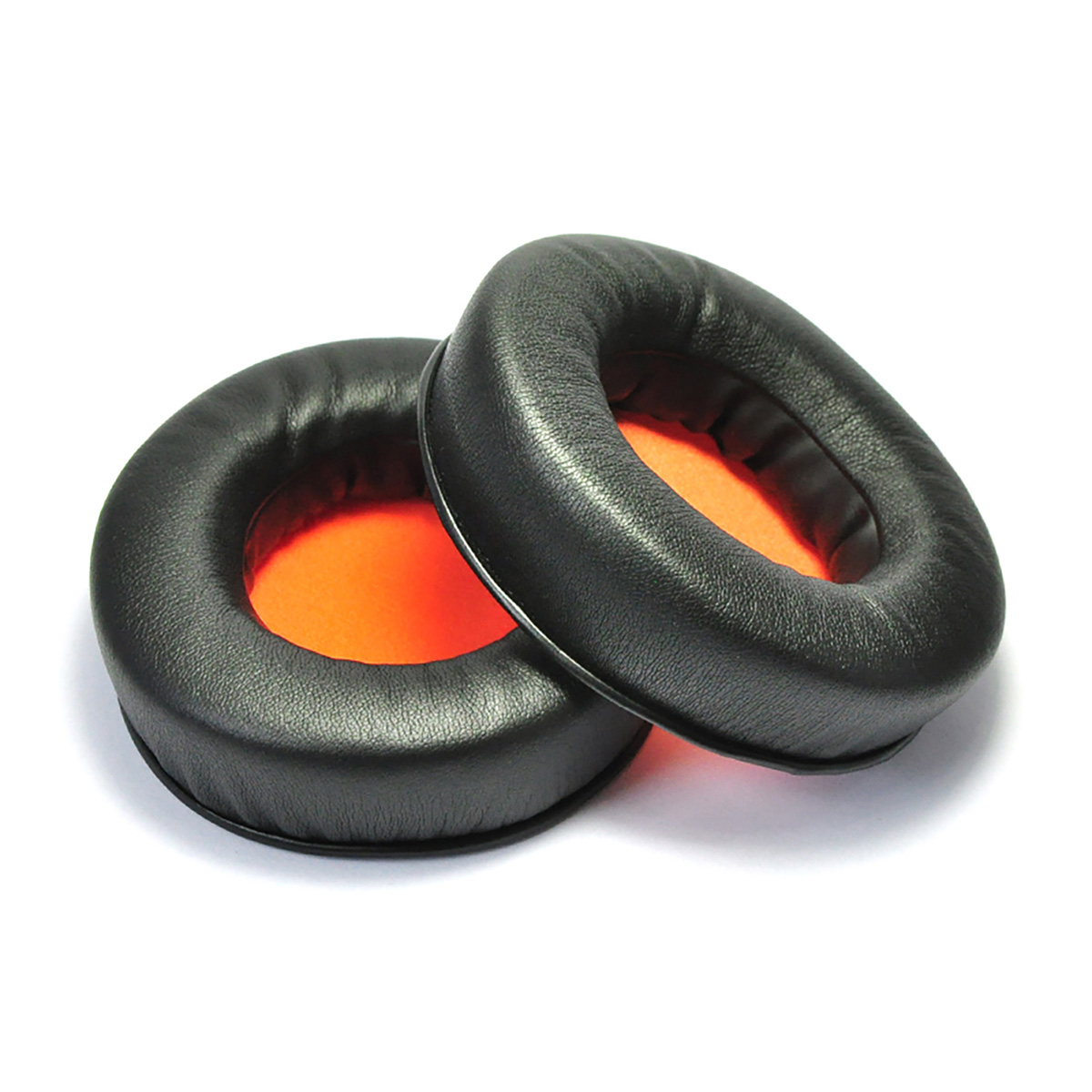 Zwei schwarze Ohrpolster mit orangefarbenem Innenraum. Sie befinden sich auf einer weißen Oberfläche.