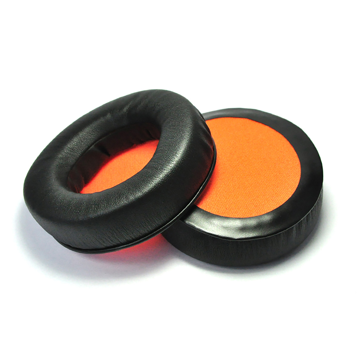 Zwei schwarze Ohrpolster mit orangefarbenem Innenstoff. Isoliert auf weißer Oberfläche.