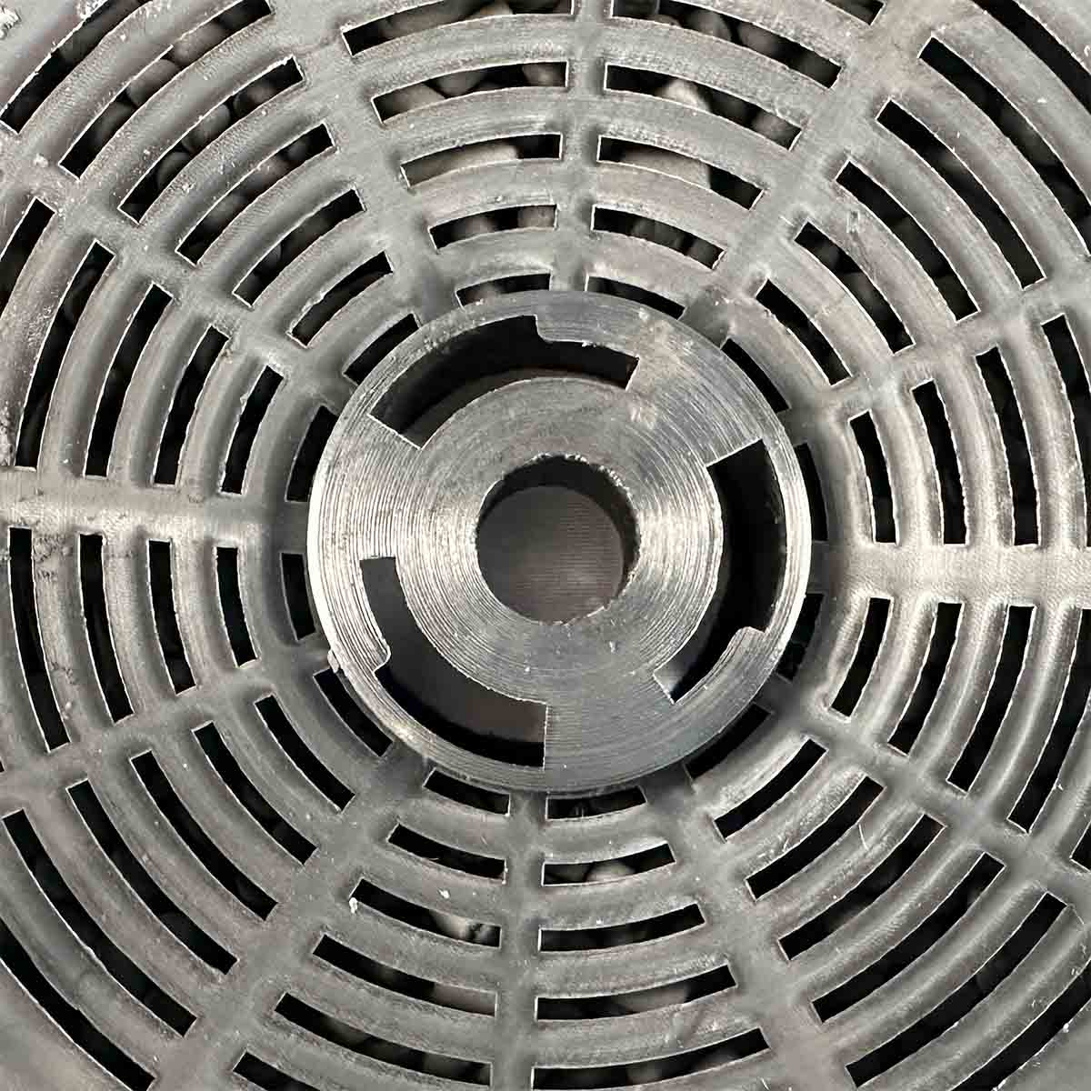Nahaufnahme einer Metallscheibe mit kreisförmigem Design und mehreren Schlitzen.