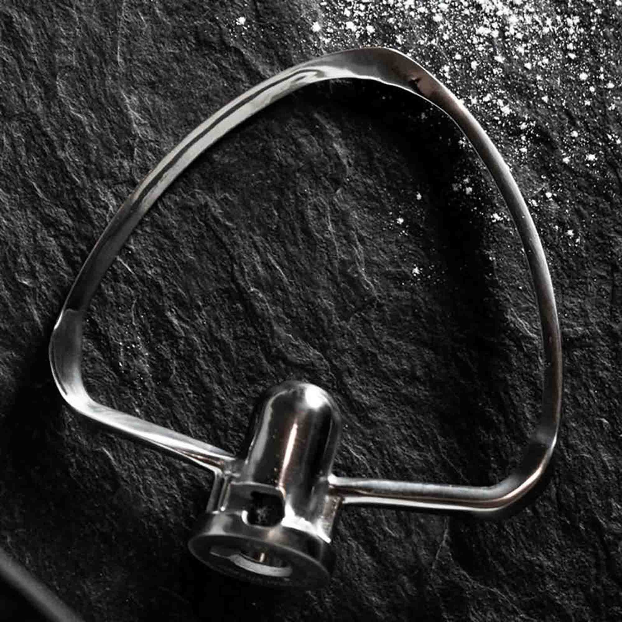 Metall-Rühraufsatz auf dunkler Oberfläche. Der Aufsatz hat eine einzigartige Form.