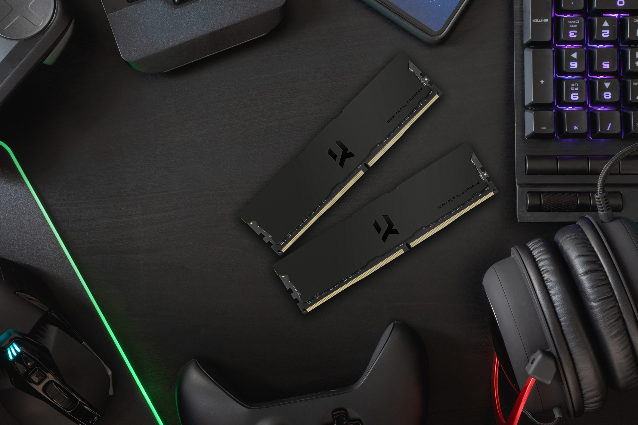 Dwa czarne paski RAM, klawiatura, mysz i słuchawki na czarnym biurku. Ustawienia do gier.