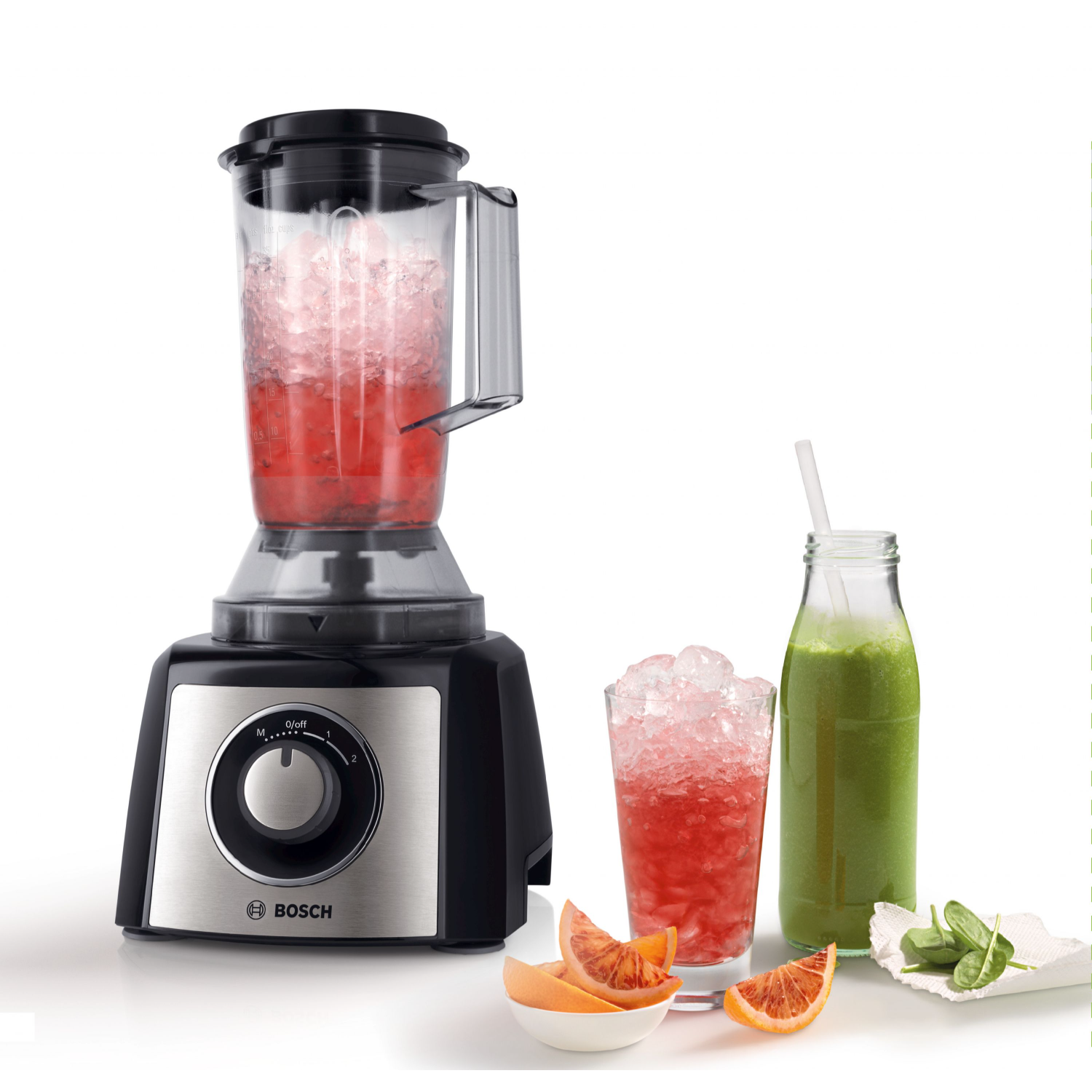 Czarny i srebrny blender z dwiema szklankami napojów i butelką zielonego soku.