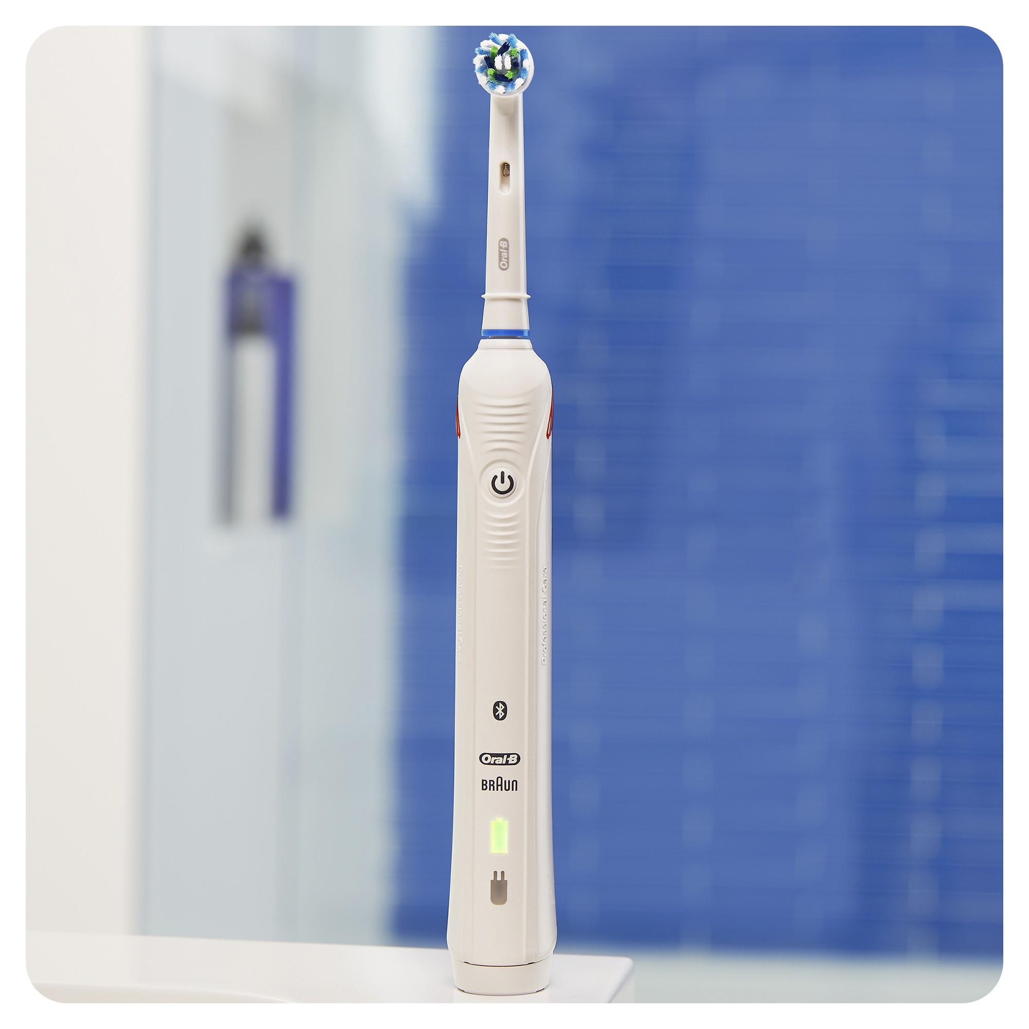 Een witte elektrische tandenborstel met een blauw accent, een groen lampje en een oplaadindicator. Blauwe achtergrond.