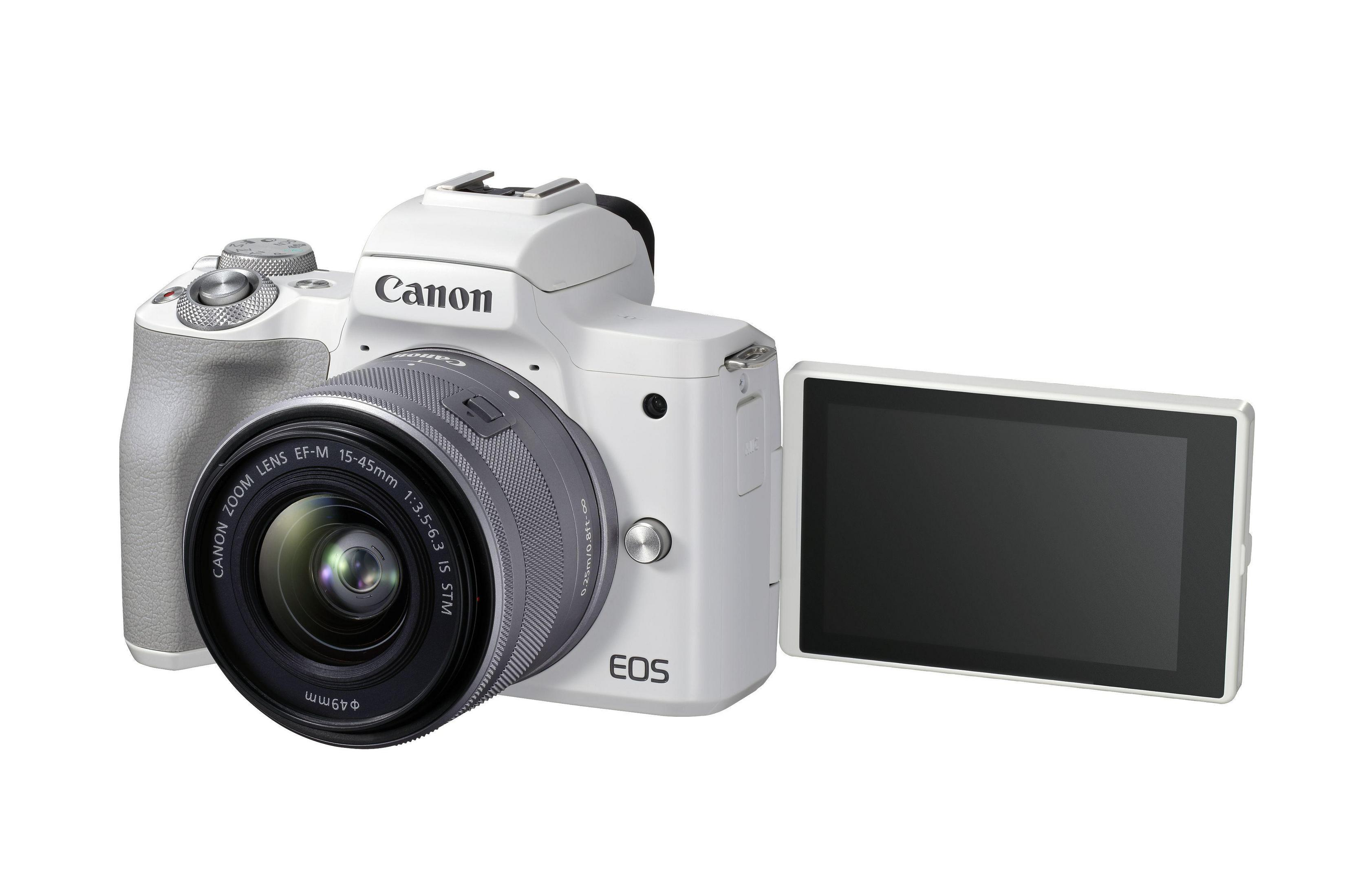 Una fotocamera Canon bianca con obiettivo e schermo ribaltabile. L'obiettivo è a fuoco.