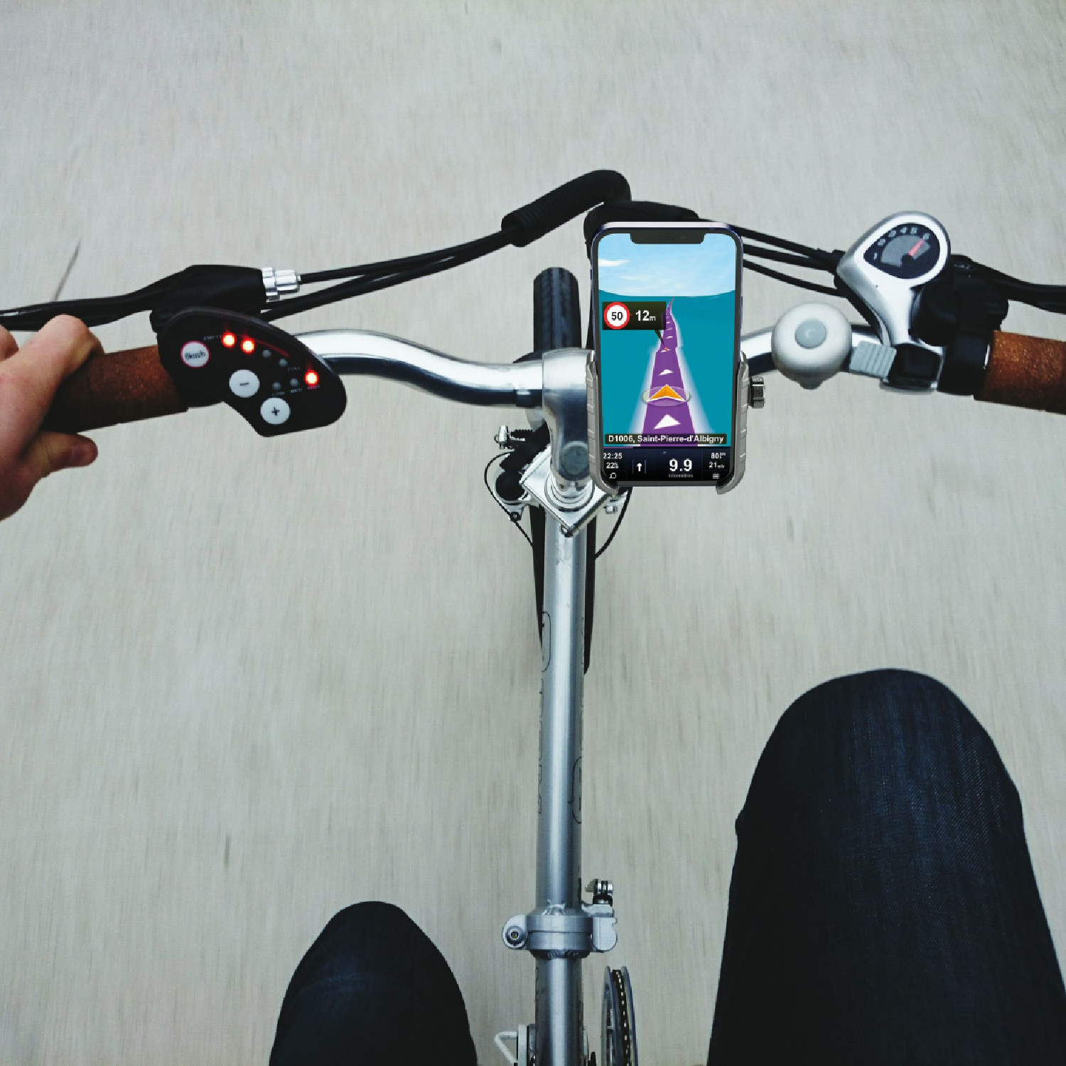 Una persona in bicicletta con un telefono che mostra un'app di navigazione sul manubrio.