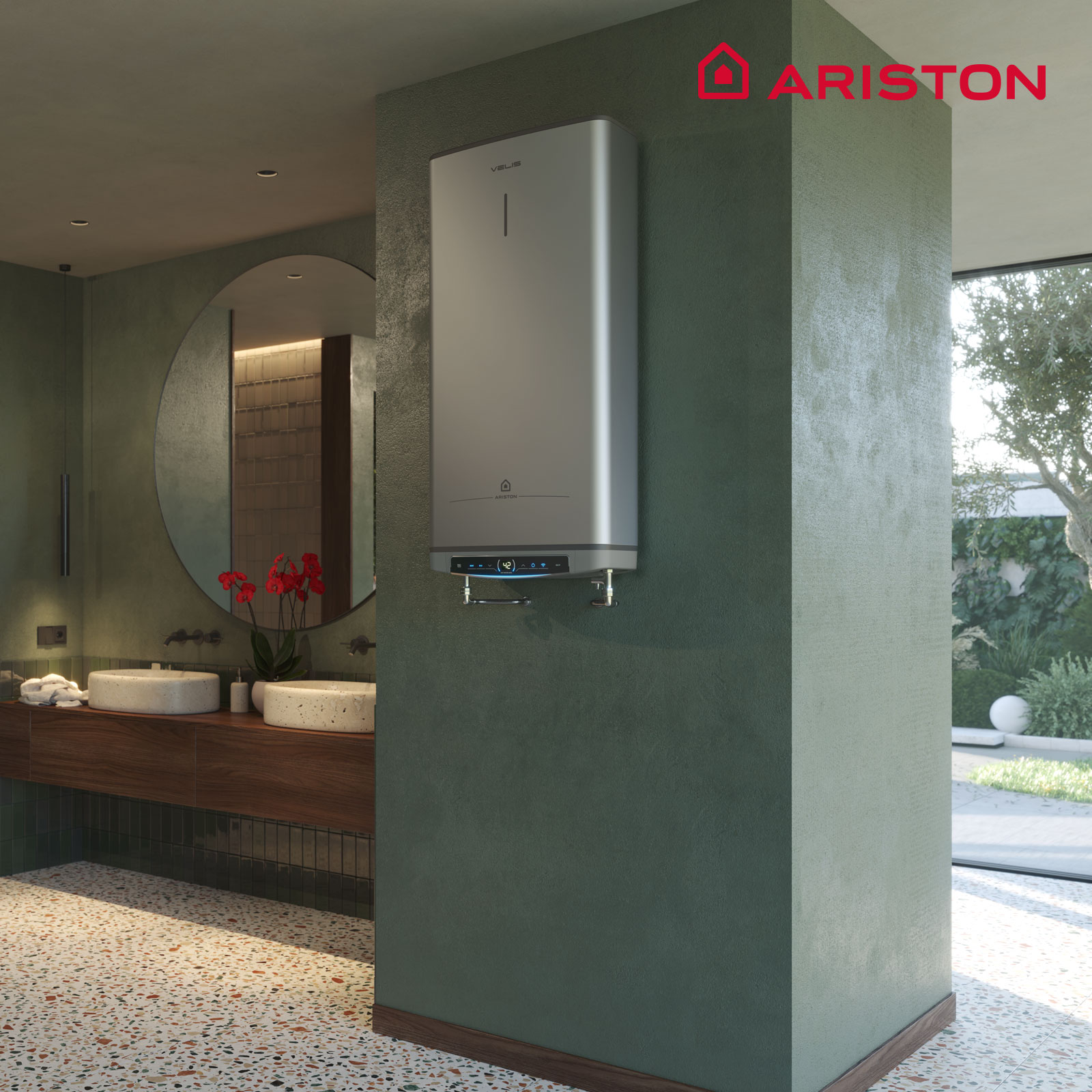Baño moderno con un calentador de pared plateado. Flores rojas en un jarrón, dos lavabos y un espejo redondo.