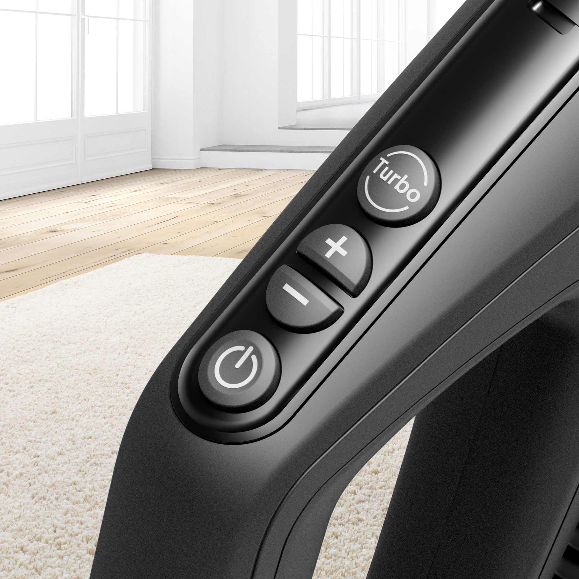 Zbliżenie czarnego uchwytu odkurzacza z przyciskami Turbo, +, -, i zasilania.