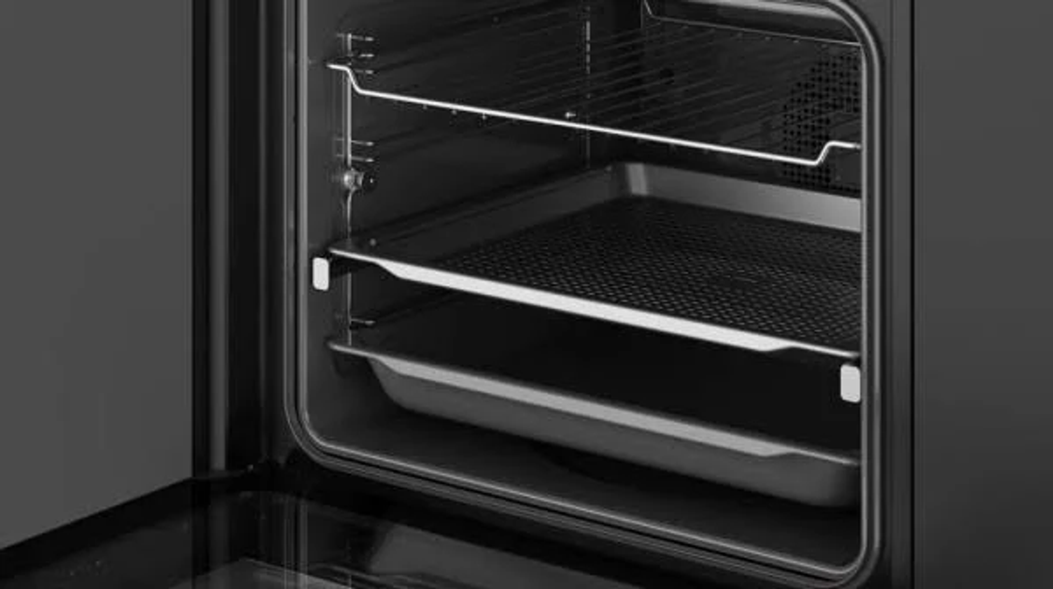 Interior del horno con dos bandejas y rejillas. El horno es negro por dentro.