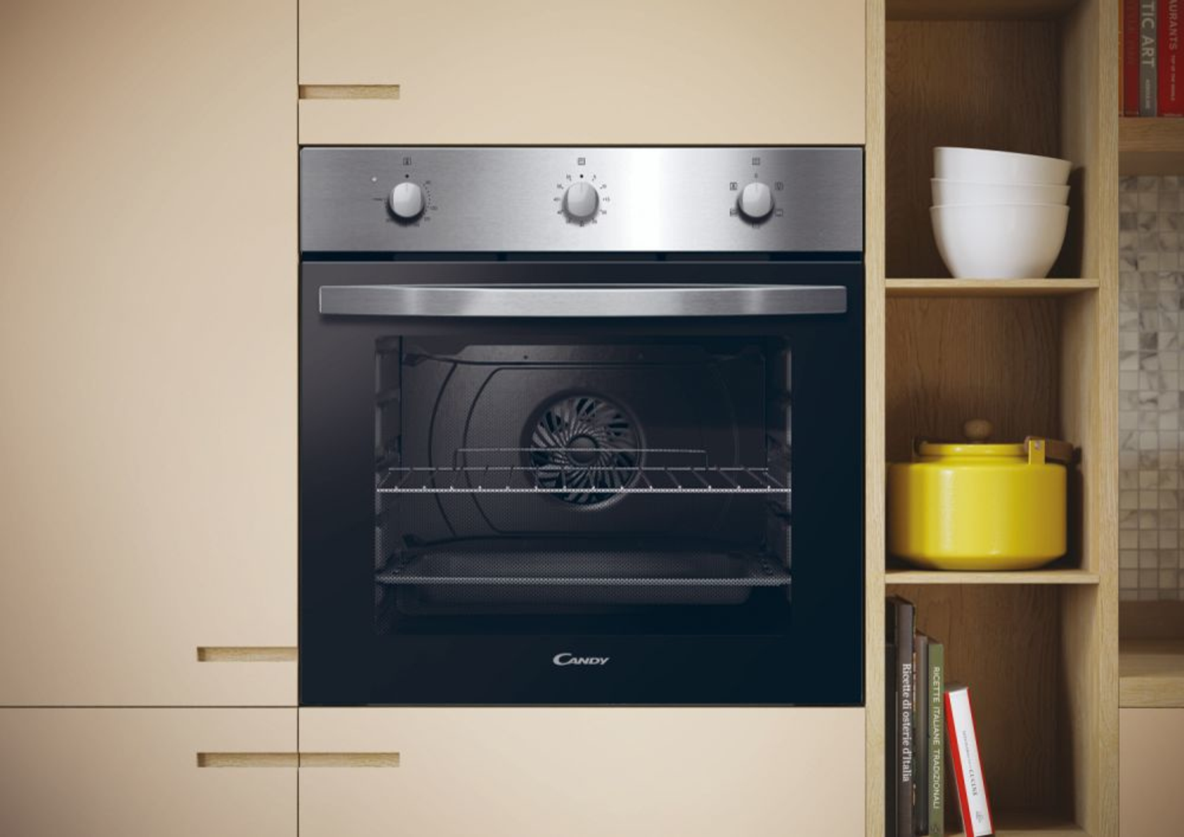 Un horno en un mueble de cocina. El horno tiene una puerta negra y controles plateados. Una olla amarilla y libros están cerca.