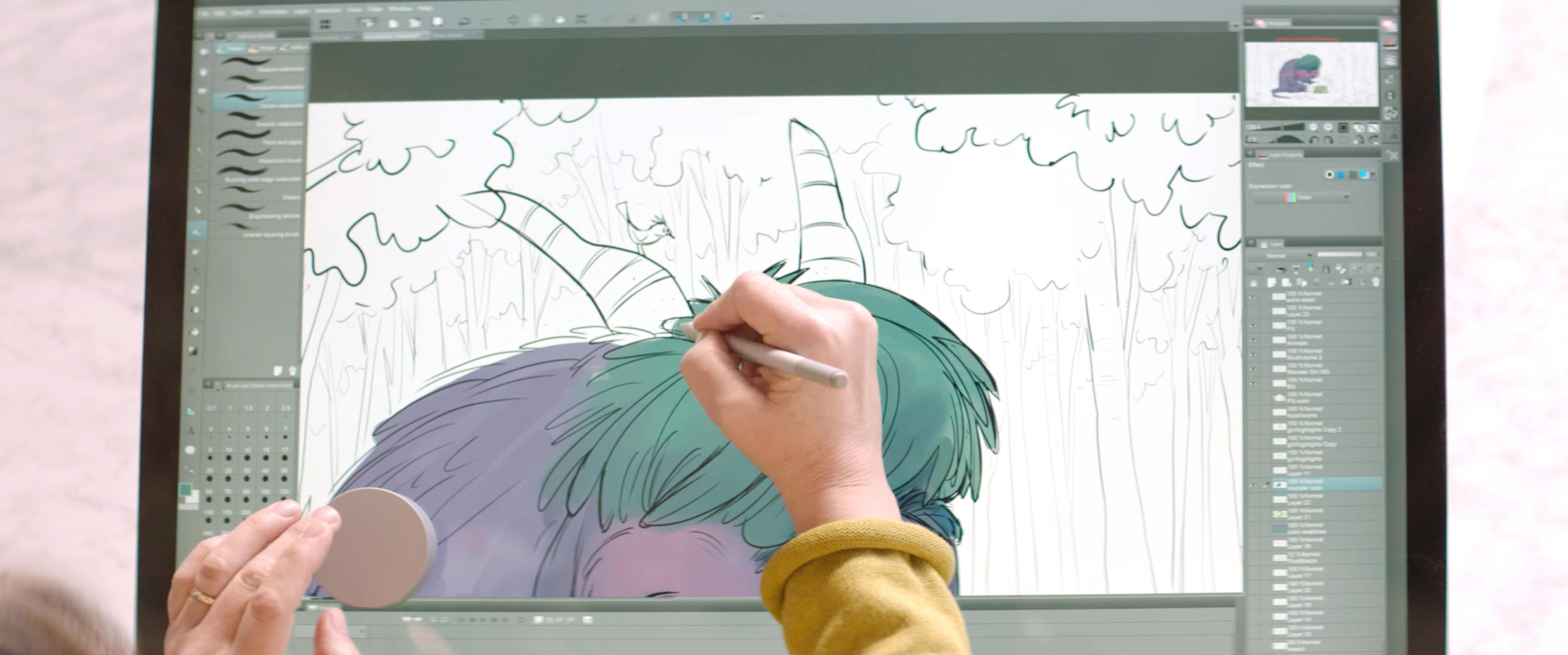 Les mains d'une personne utilisant un stylet sur un écran d'ordinateur, dessinant un dessin animé.