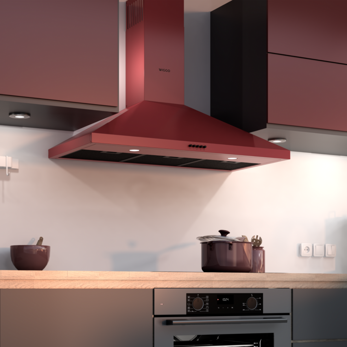 Red kitchen hood installed in a kitchen setting. The brand 'Wiggo' is visible. Cabinets are red.