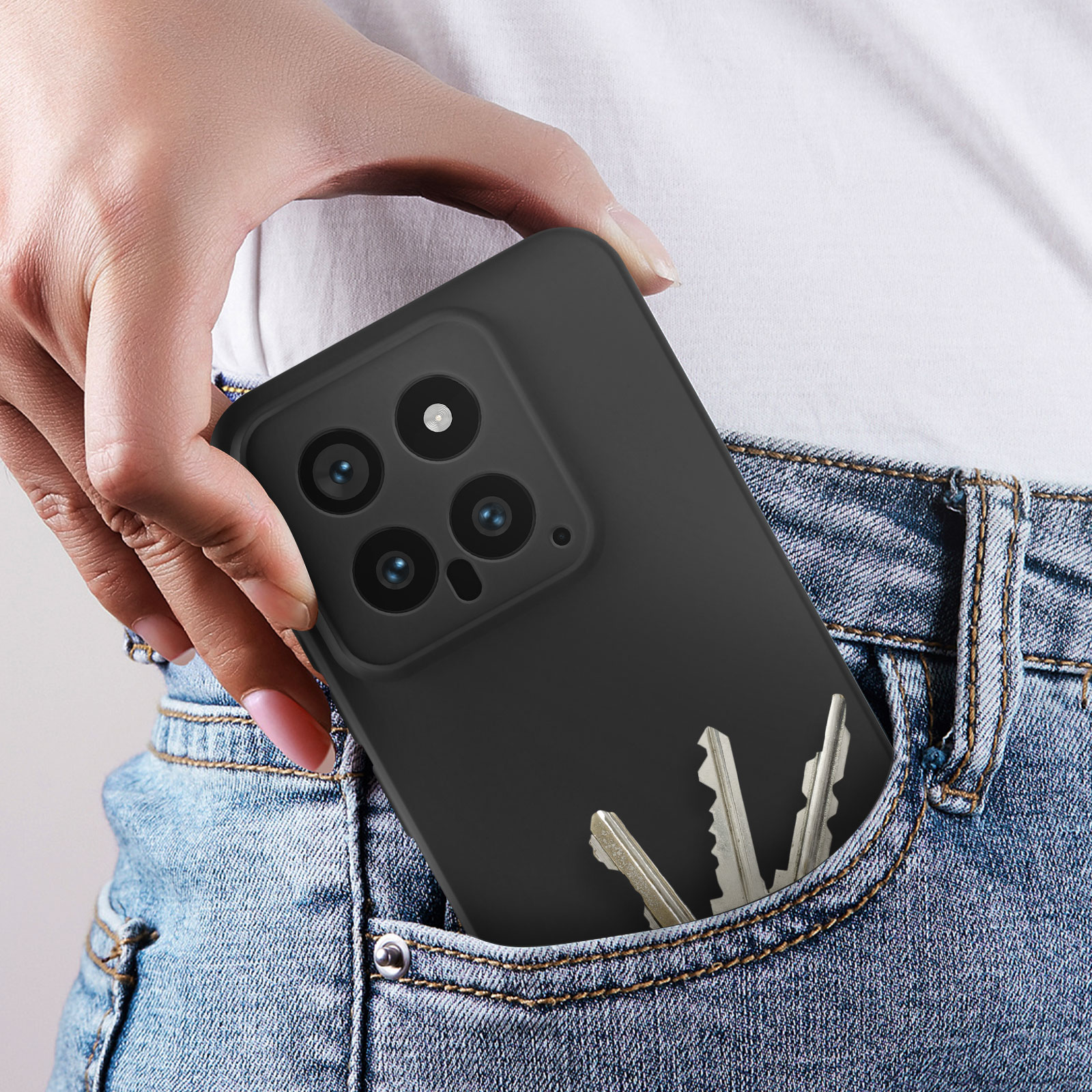 Una mano mette un telefono in una tasca dei jeans. Le chiavi sono anche nella tasca.