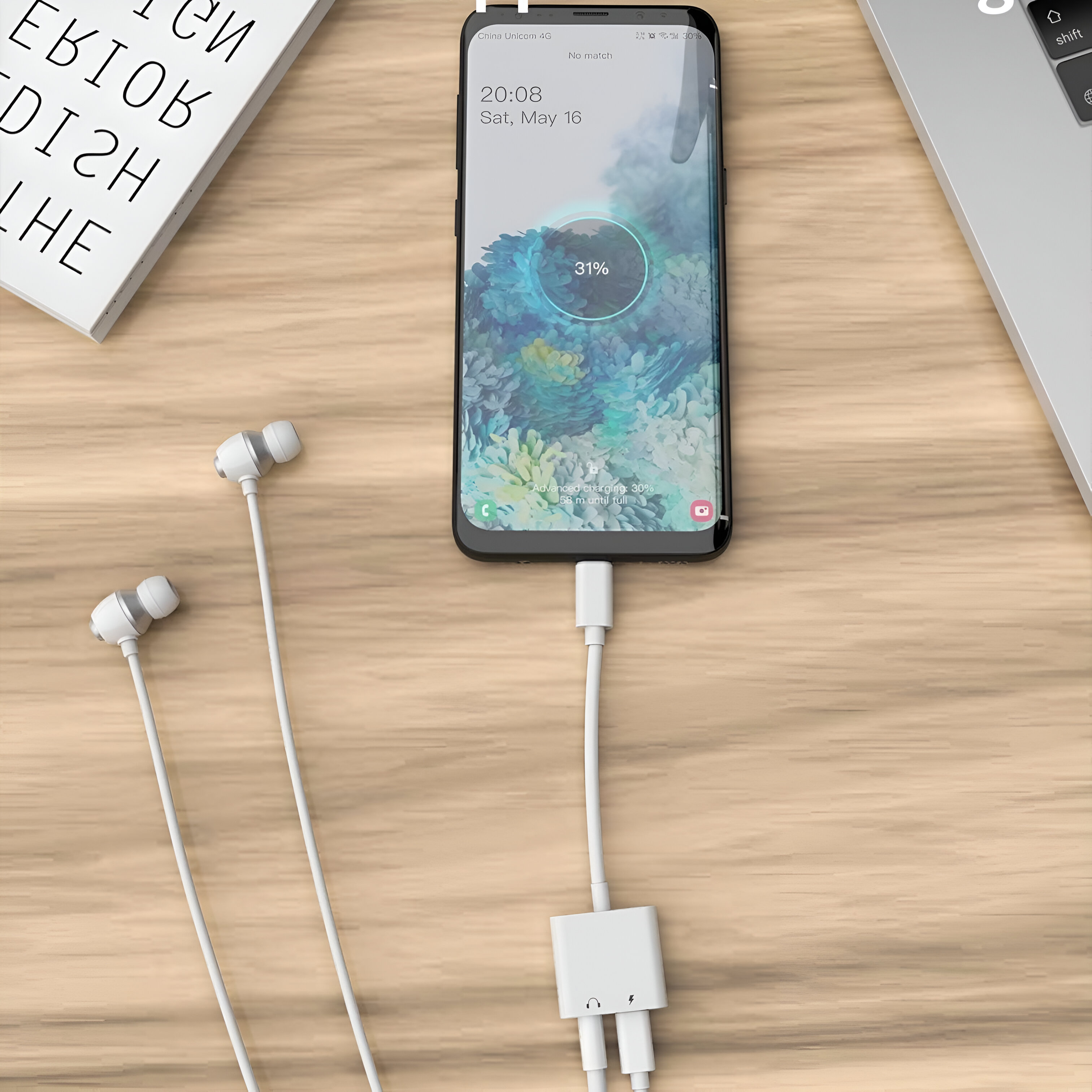 Un teléfono inteligente conectado a un cargador y auriculares sobre una superficie de madera.