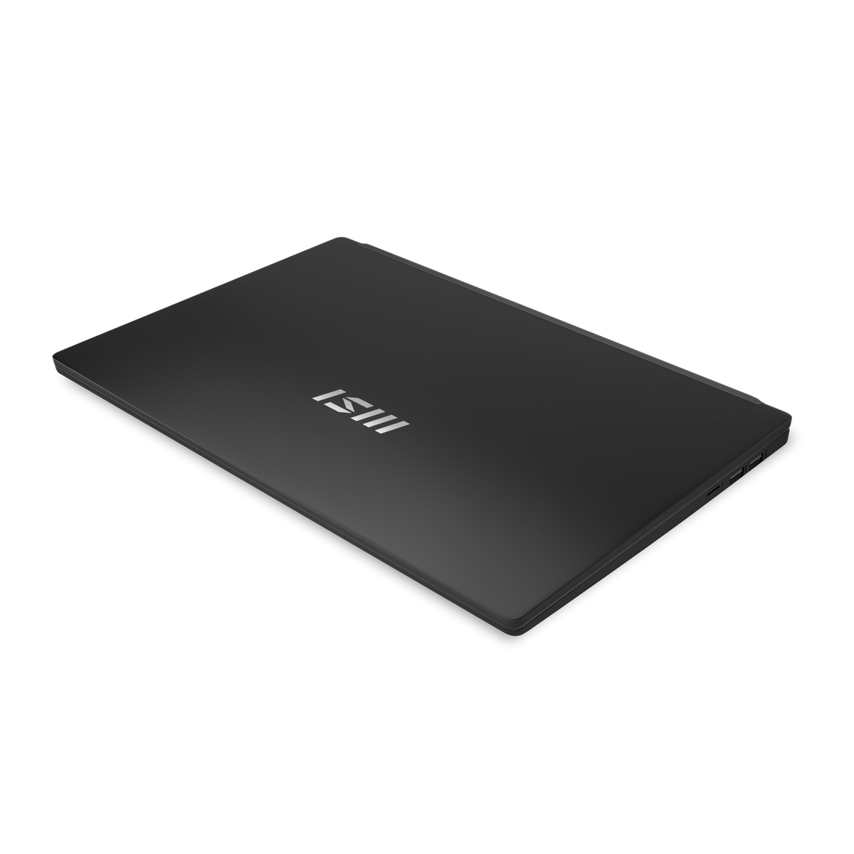 Una laptop negra cerrada con el logo MSI. La laptop está sobre una superficie negra.