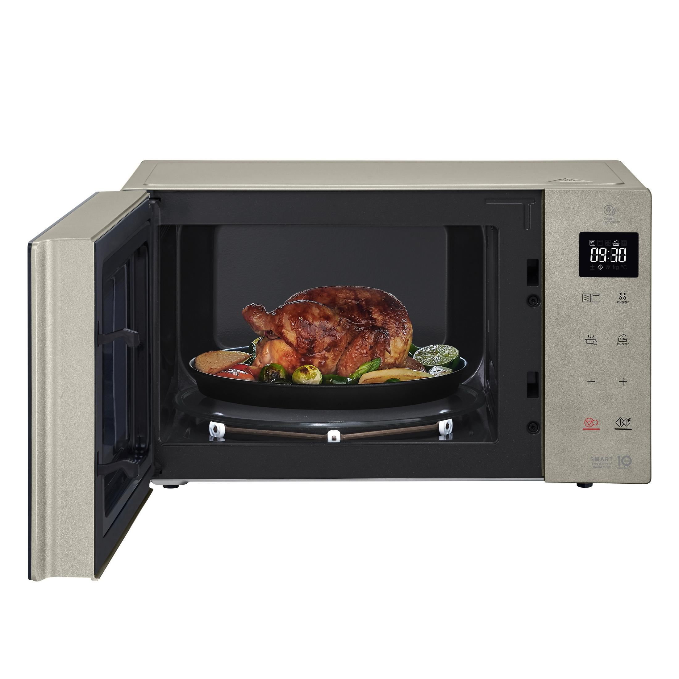 Horno microondas con puerta abierta. Un pollo asado y verduras están dentro.