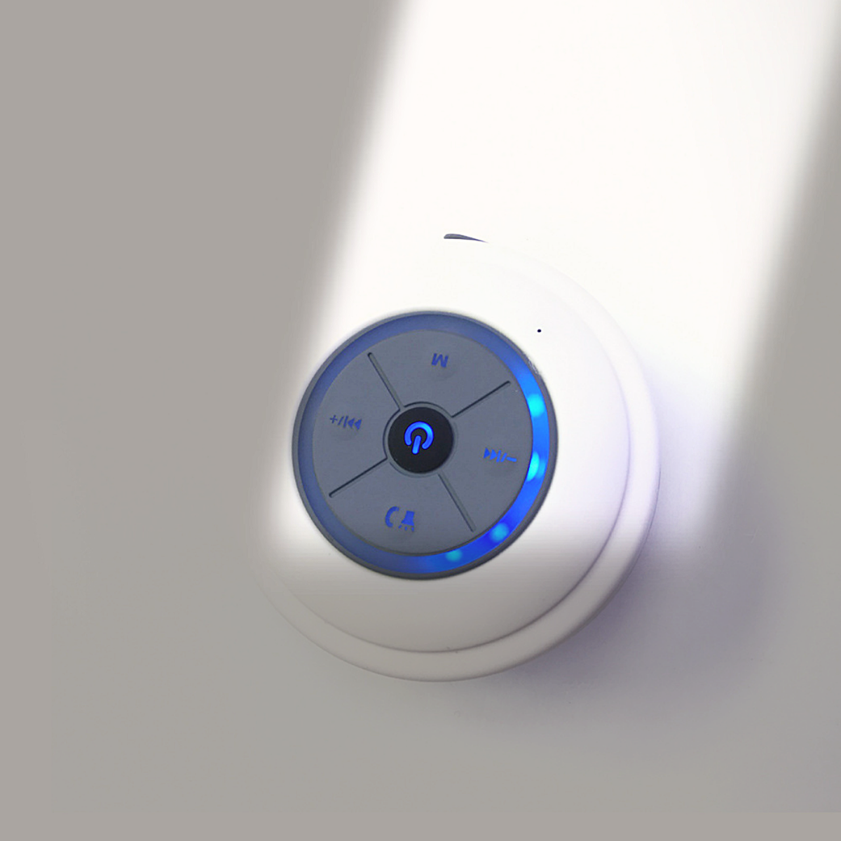 Weißes rundes Gerät mit Knöpfen und blauem Licht, an der Wand befestigt.