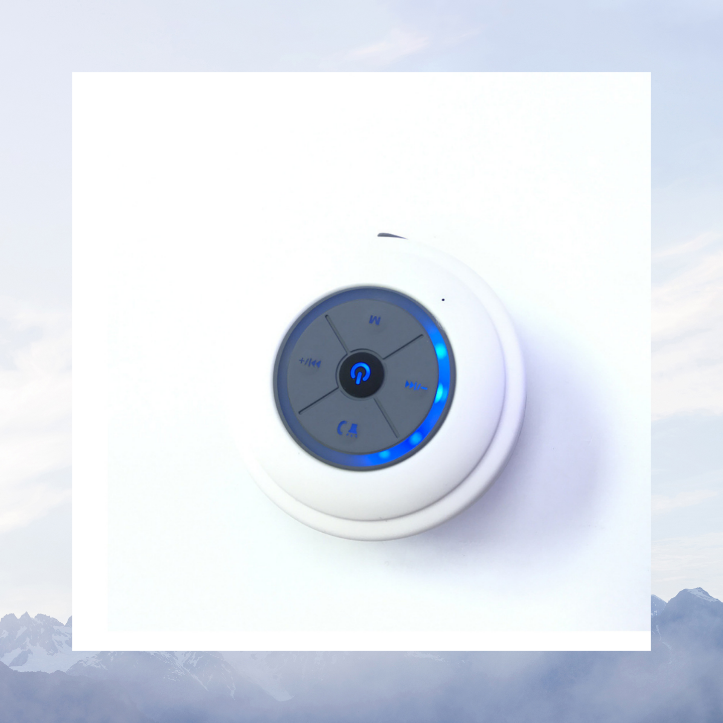 Ein weißer, runder Bluetooth-Lautsprecher mit Knöpfen.