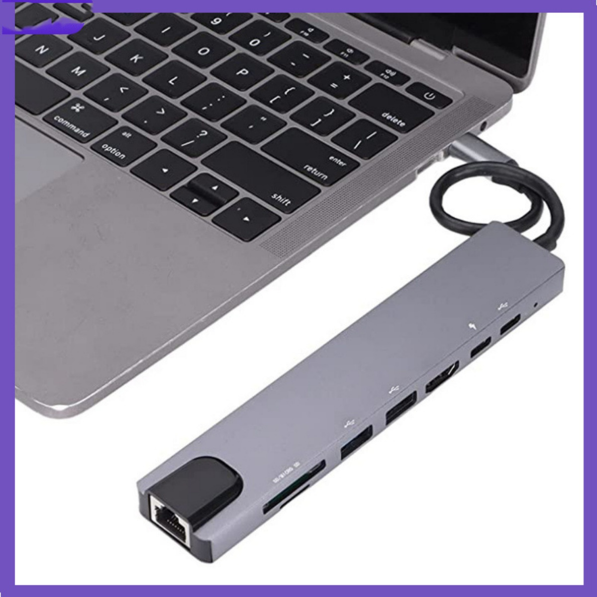 Ein Laptop, der mit einem grauen Hub mit mehreren Anschlüssen verbunden ist. Der Hub befindet sich auf einer weißen Oberfläche.