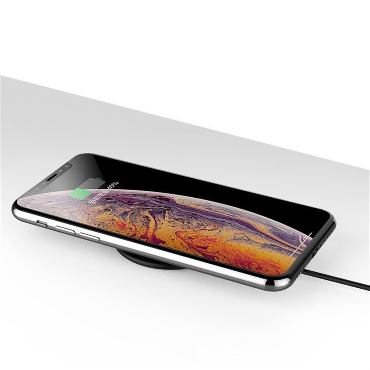 Smartphone, das auf einem kabellosen Ladepad geladen wird. Der Bildschirm zeigt den Ladefortschritt.