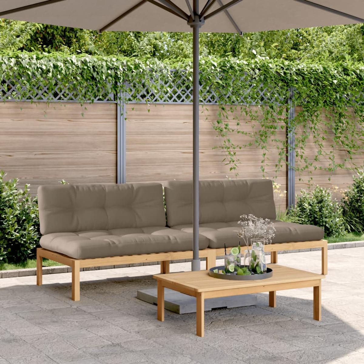 Ein Sitzbereich im Freien: ein Sofa mit Kissen, ein Tisch und ein Sonnenschirm. Der Hintergrund ist ein Zaun.