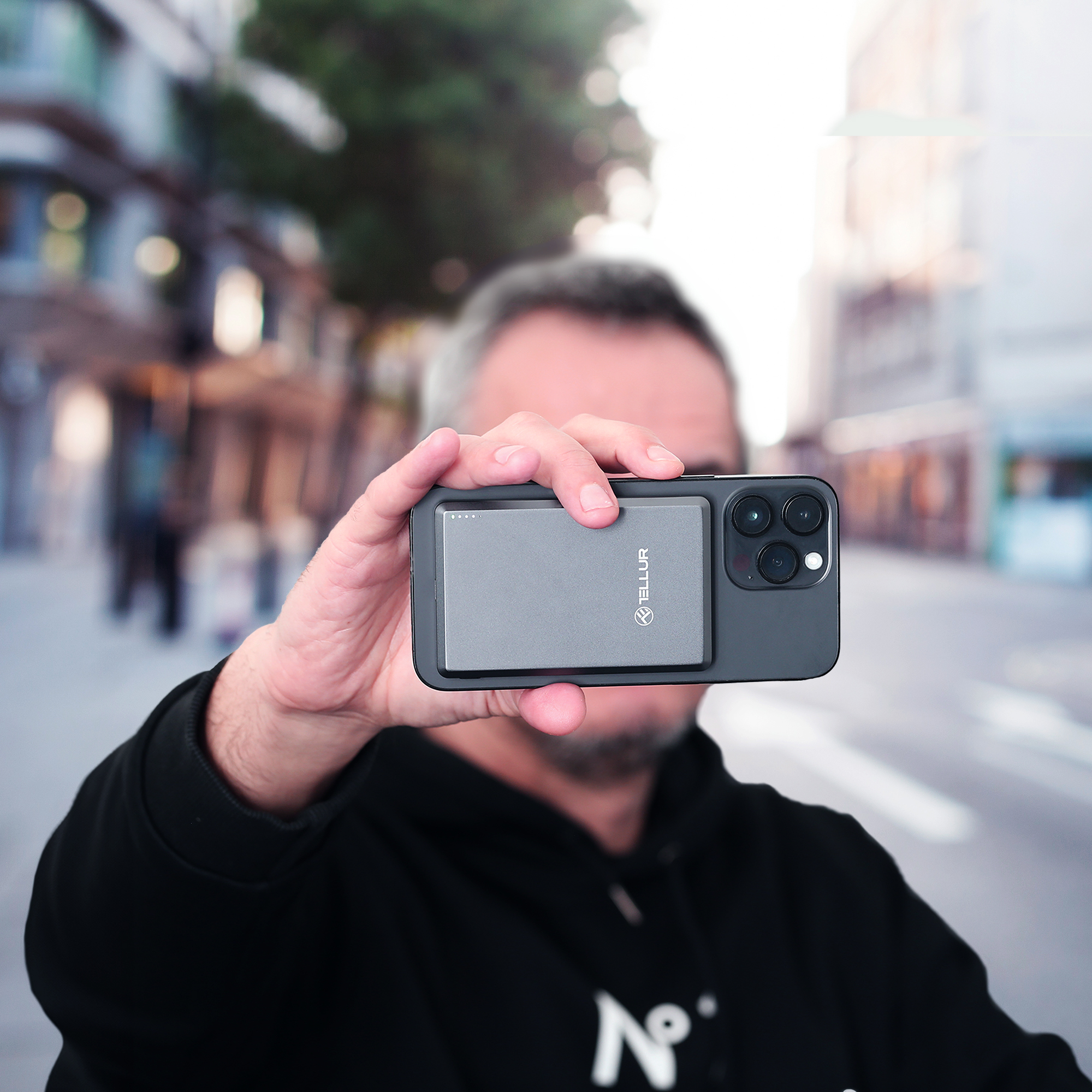 Mężczyzna trzymający telefon z dołączonym szarym etui.