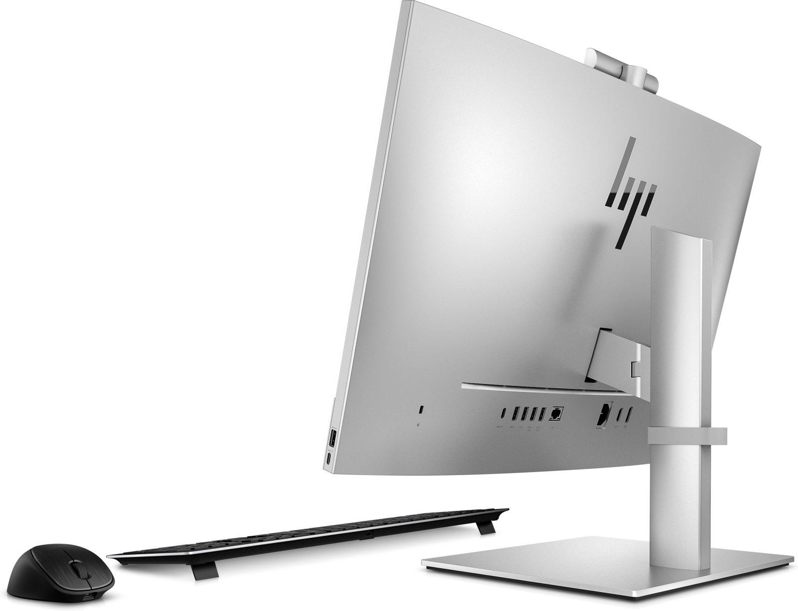 Silberner Computermonitor mit Tastatur und Maus auf weißer Oberfläche.
