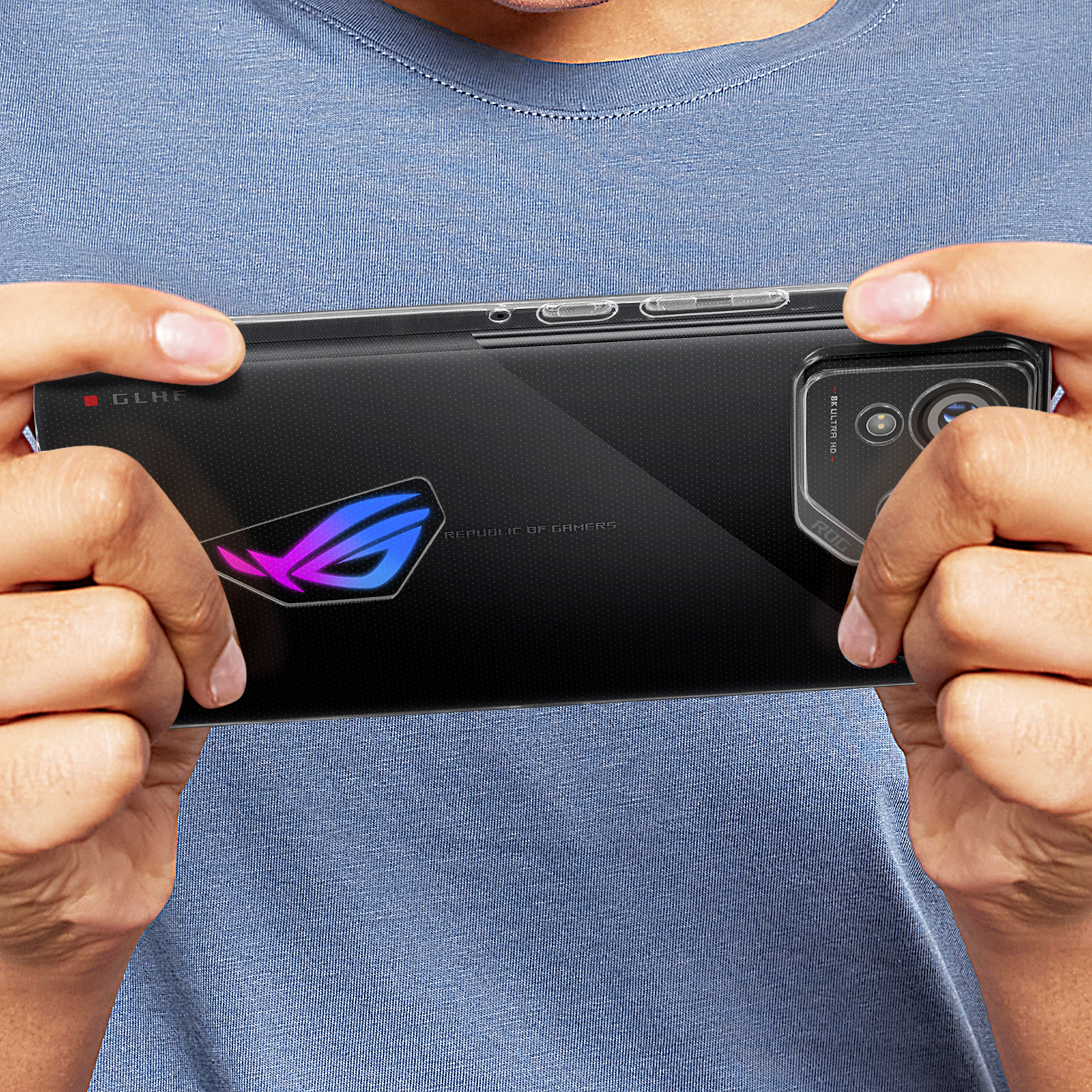 Mani che tengono un telefono nero con un logo ROG colorato. Texture nera. Sfondo sfocato.
