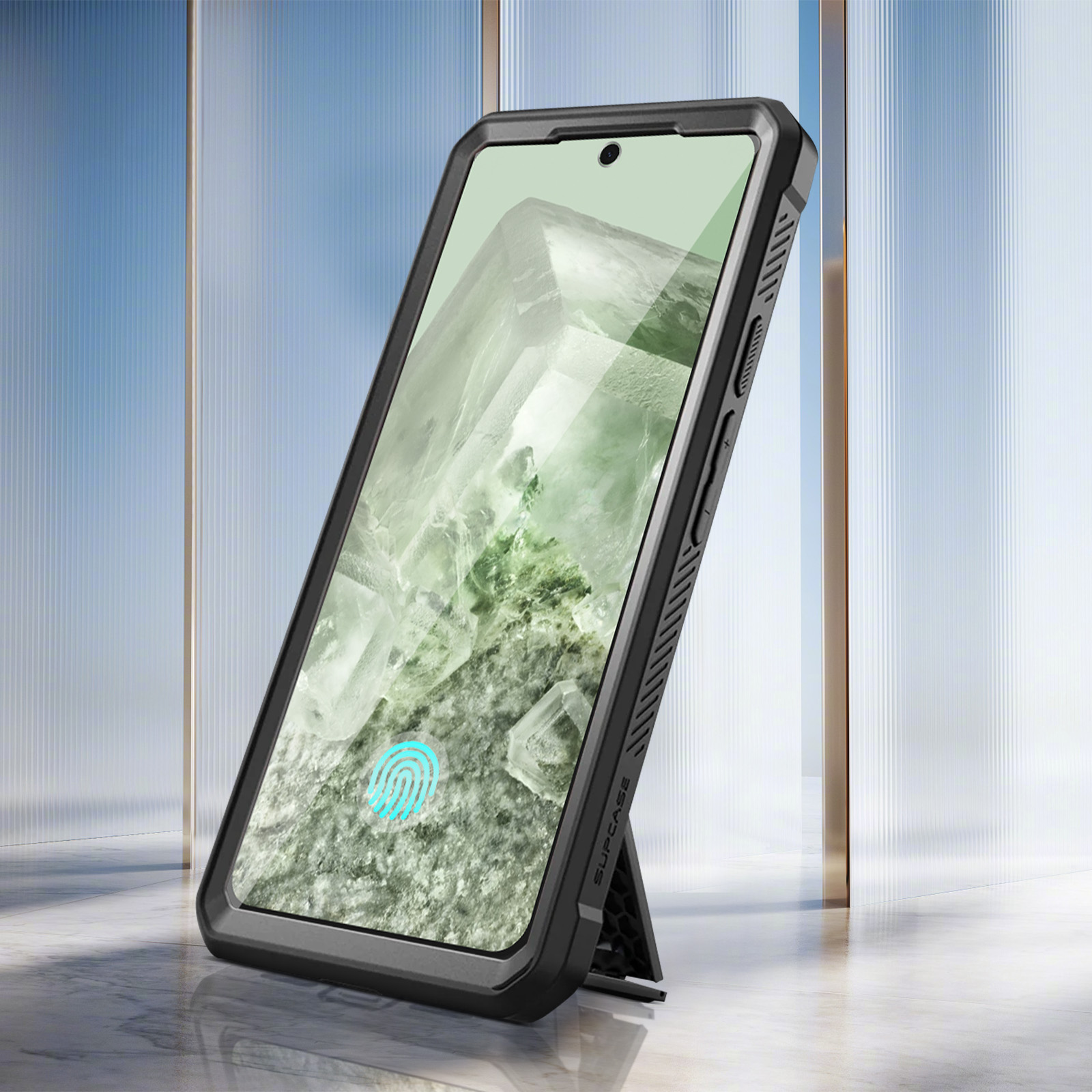 Ein Smartphone in einer schwarzen Schutzhülle, das an einem Glas-Hintergrund lehnt.