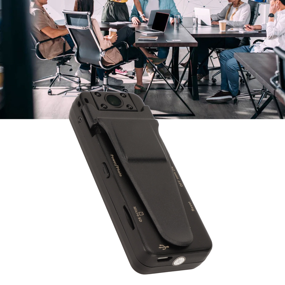 Kleine schwarze Kamera mit Clip. Personen in einer Besprechung sind im unscharfen Hintergrund sichtbar.