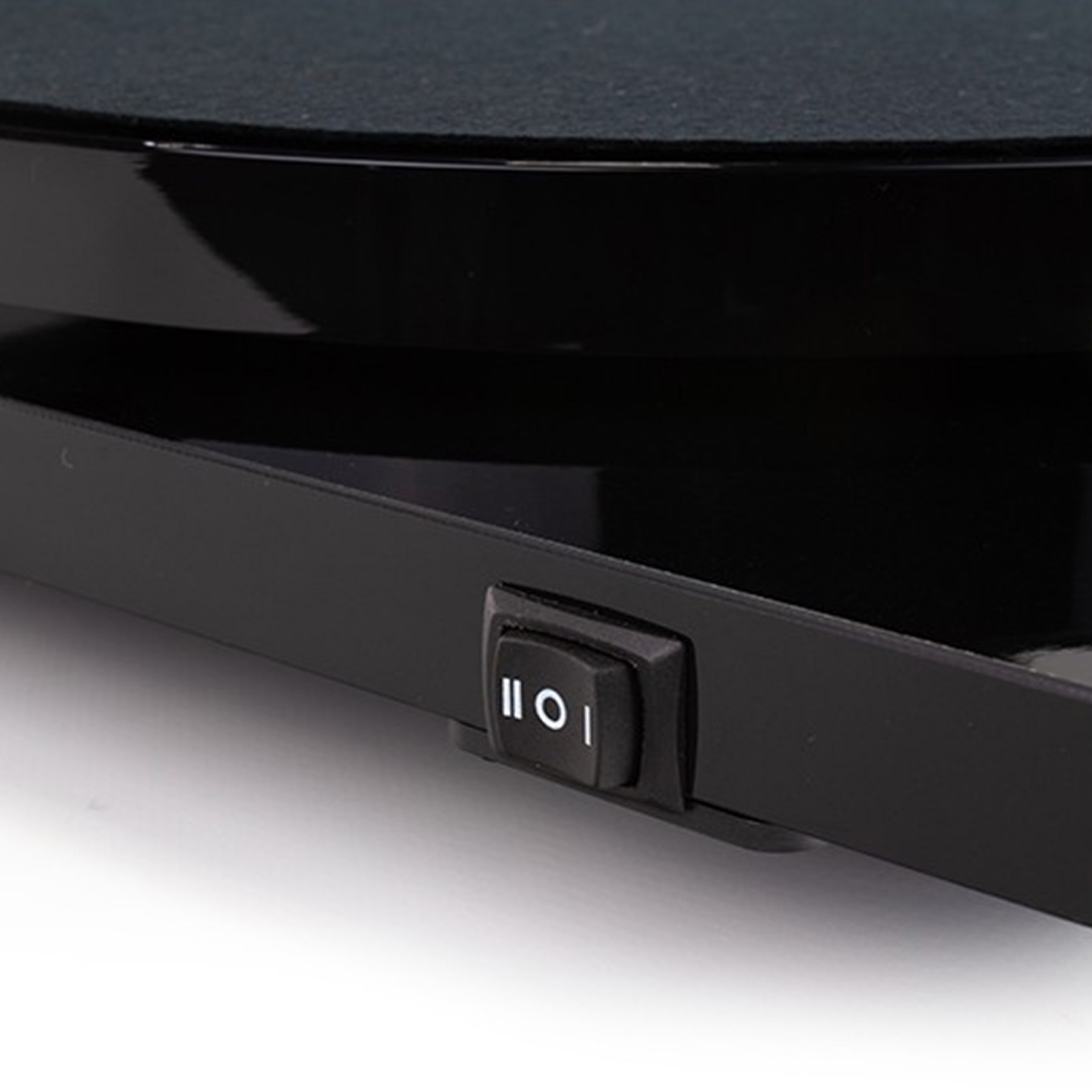 Zbliżenie czarnego przycisku zasilania z symbolami 'I' i 'O' na czarnej powierzchni.