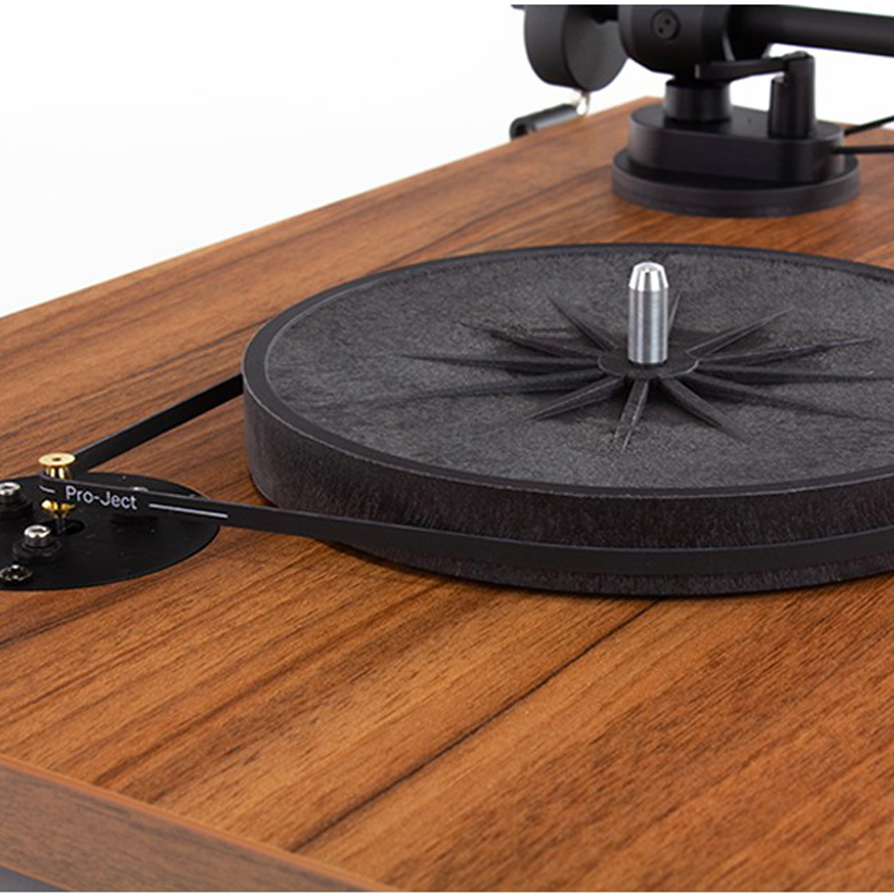 Drewniany gramofon z czarnym talerzem i paskiem. Zbliżenie.