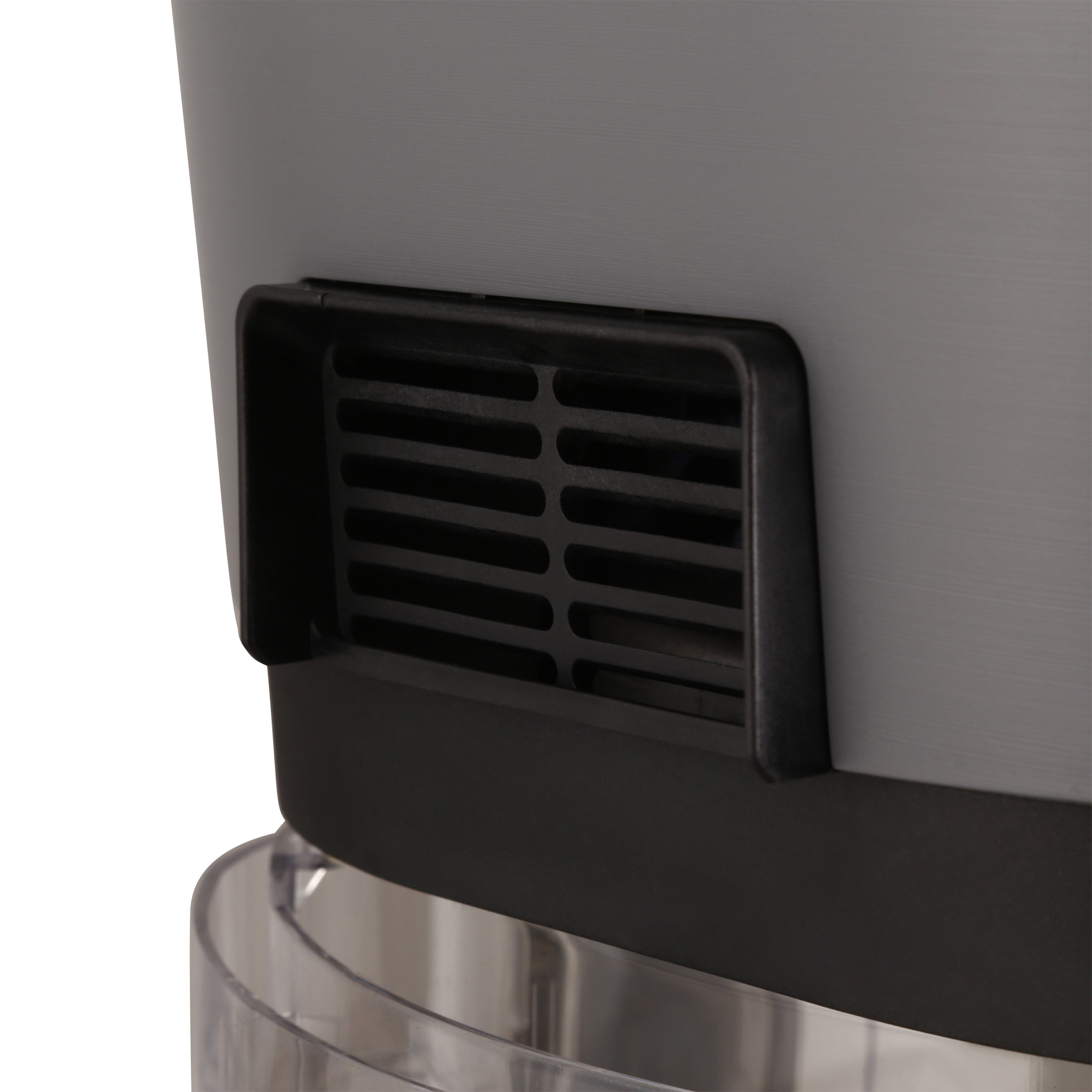 Primo piano di un dispositivo grigio e nero con fessure di ventilazione. Il dispositivo è su un supporto trasparente.
