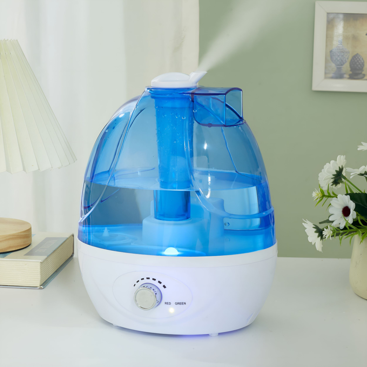 Weißer und blauer Luftbefeuchter mit Wasser. Eine Lampe und Blumen im Hintergrund.