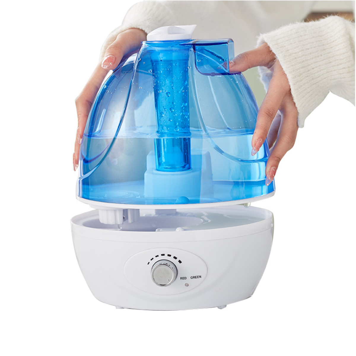 Hände halten einen blauen Luftbefeuchter mit weißer Basis, Wasser sichtbar.
