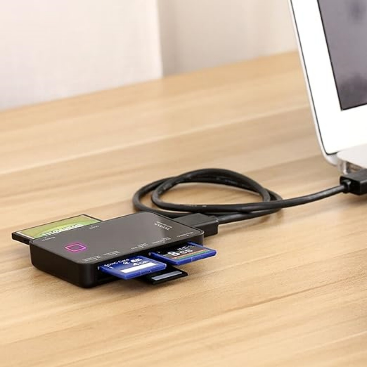 Kartenlesegerät mit eingelegten Karten. Es ist an einen Laptop auf einem Holztisch angeschlossen.