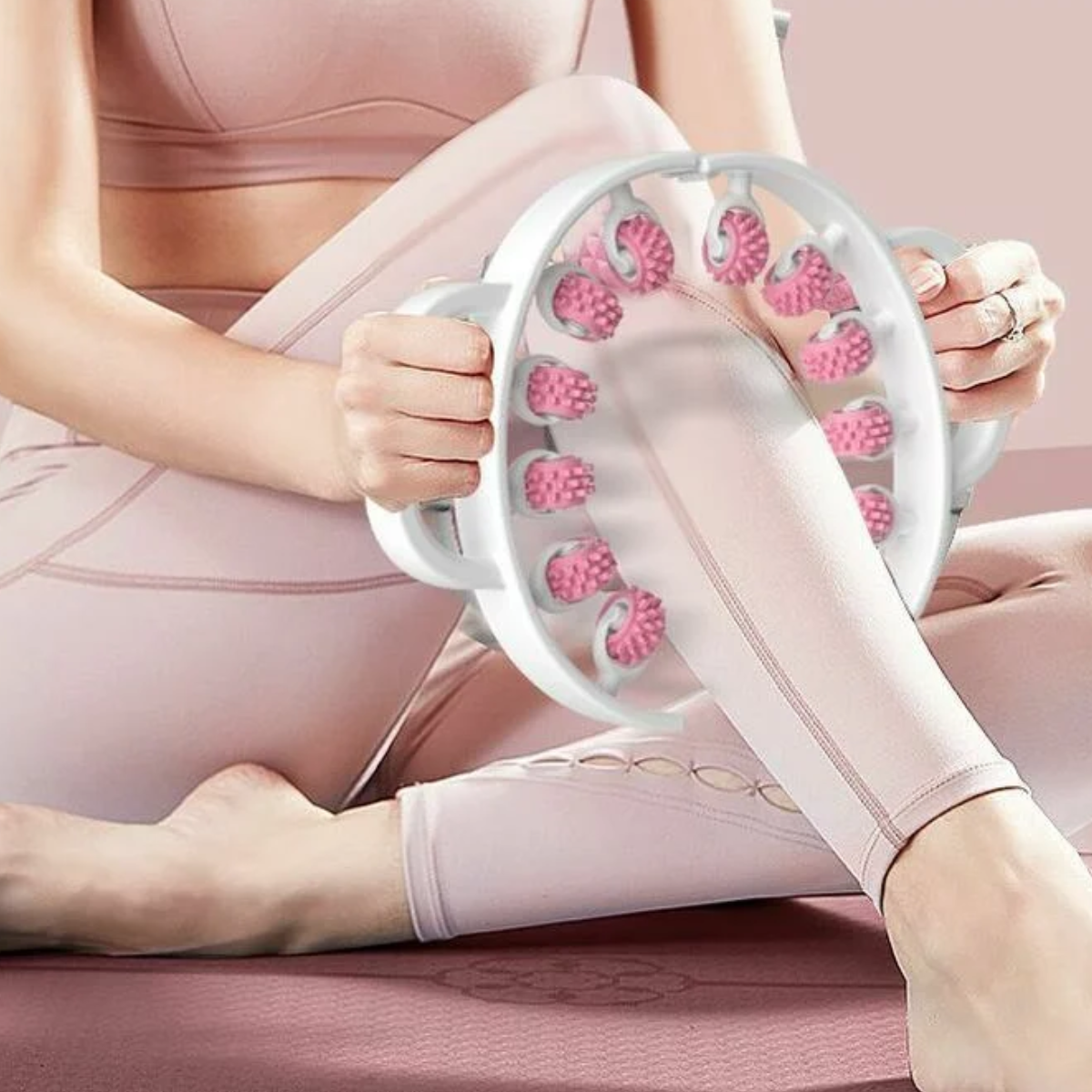 Eine Frau benutzt ein rosa Massagegerät an ihren Beinen. Es hat rotierende rosa Massagekugeln.